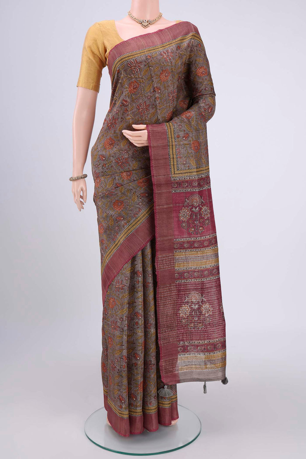Davys Grey Tussar Silk Saree with Printed design on the body and Fancy Border.  displayed on a mannequin