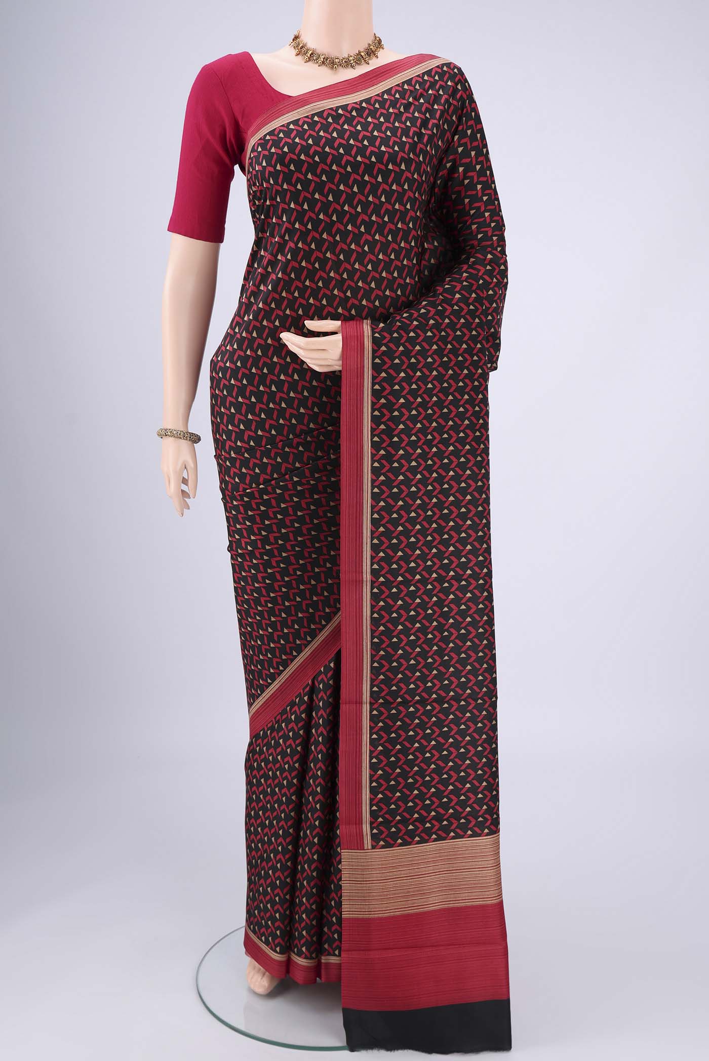 Black Printed Silk Saree with Floral Print on the body and Printed Border.  displayed on a mannequin