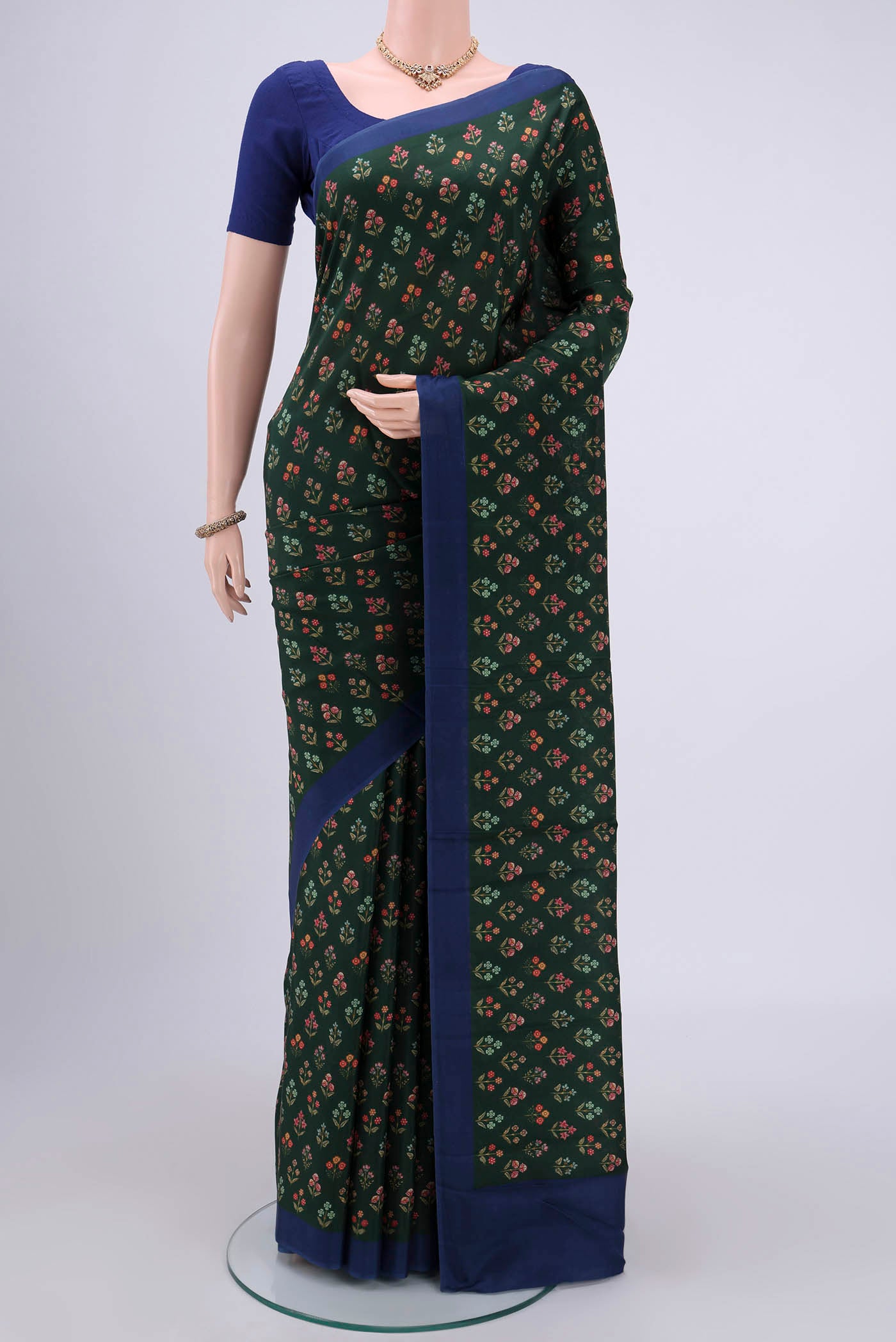 Bottle Green Printed Silk Saree with Printed design on the body and Plain Border.  displayed on a mannequin