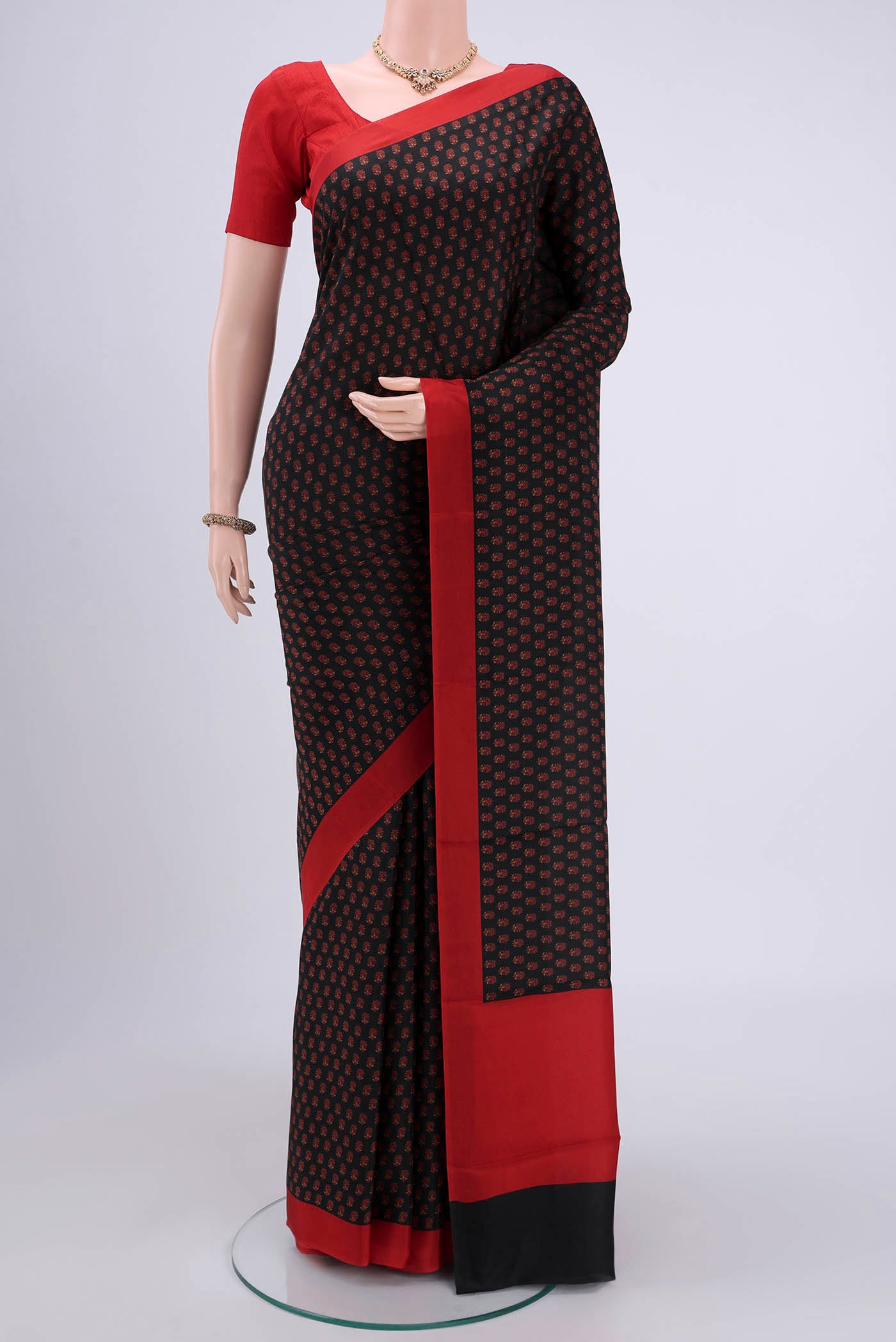 Black Printed Silk Saree with Printed design on the body and Plain Border.  displayed on a mannequin
