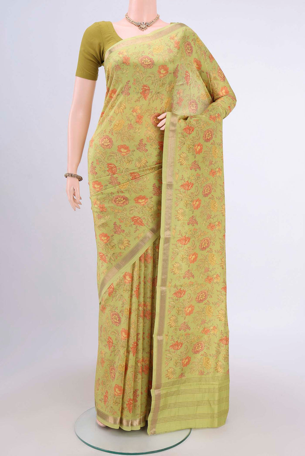 Light Green Crepe Saree with Floral Print on the body and Plain Border.  displayed on a mannequin