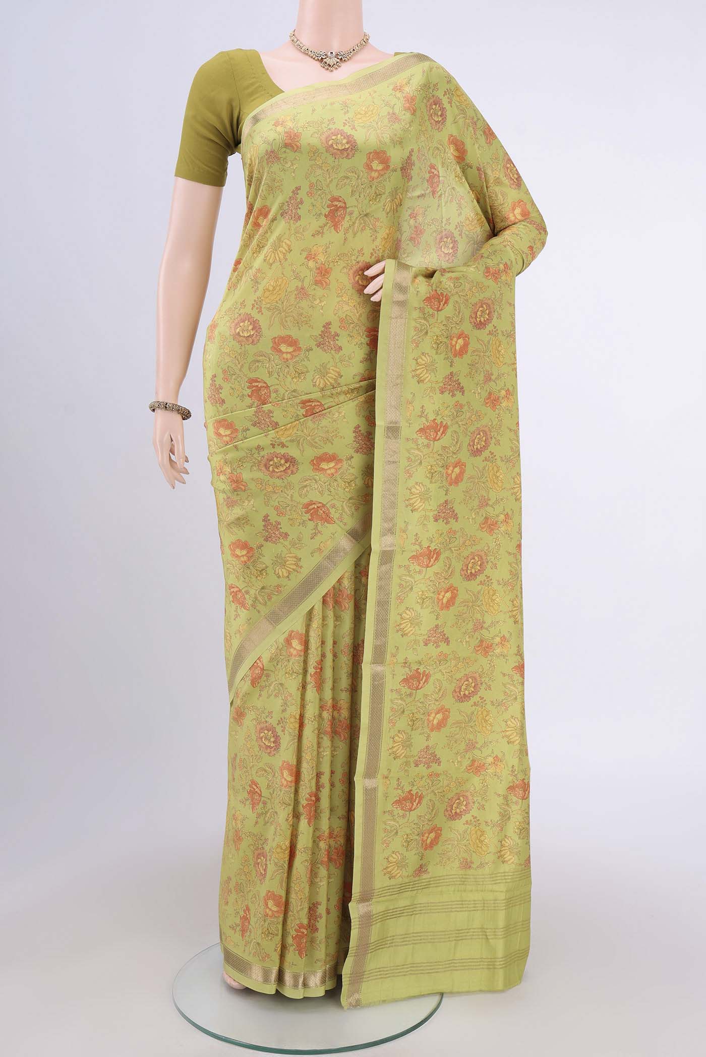 Light Green Crepe Saree with Floral Print on the body and Plain Border.  displayed on a mannequin