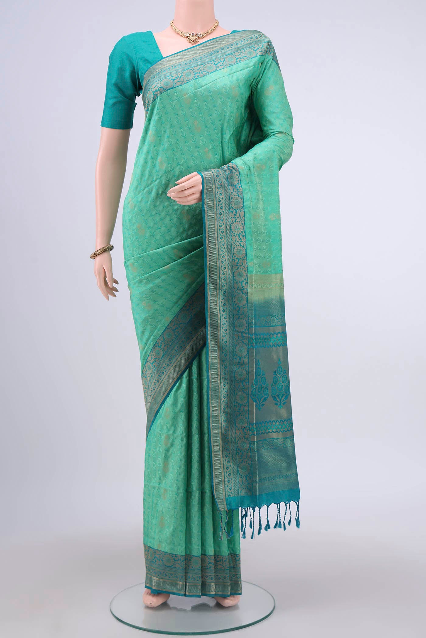 Turquoise Soft Silk Saree with Jacquard design on the body and Zari Border displayed on a mannequin