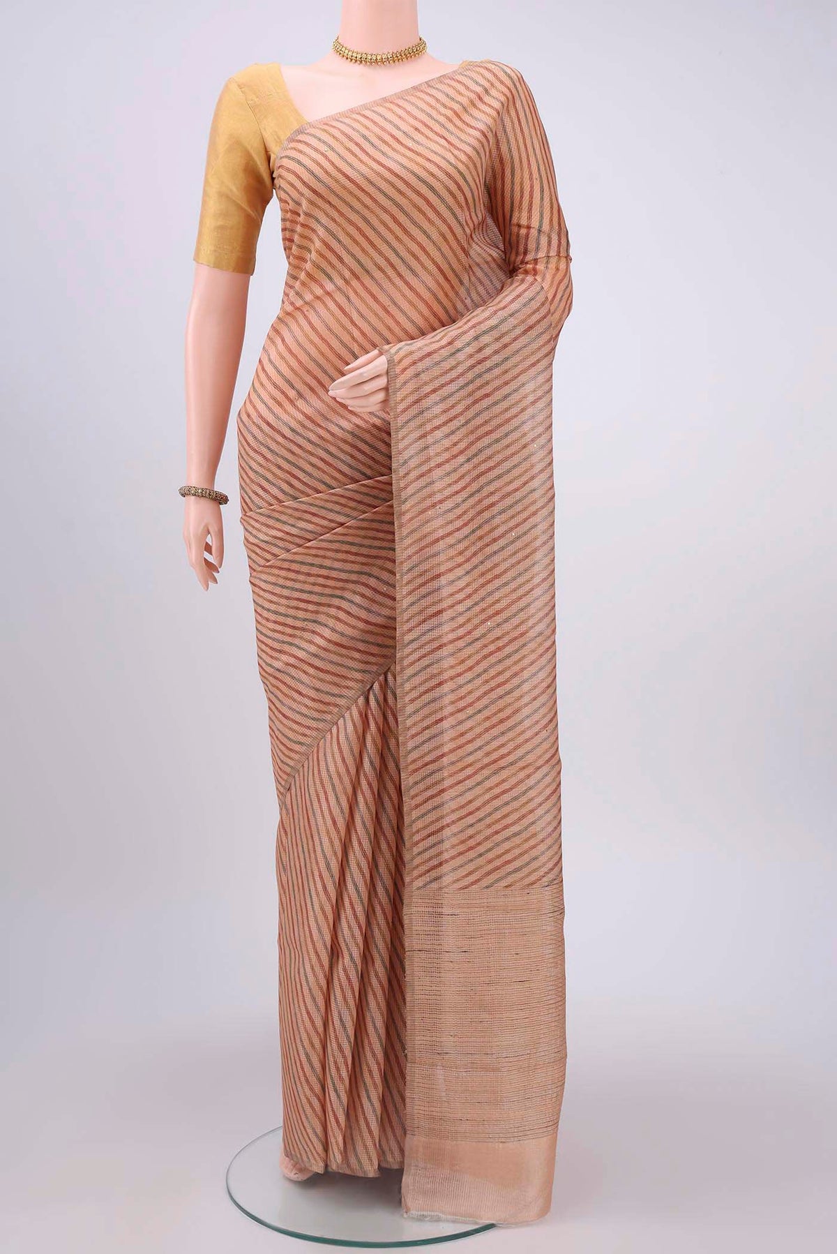 Peach Tussar Silk Saree with Printed design on the body and Printed Border displayed on a mannequin