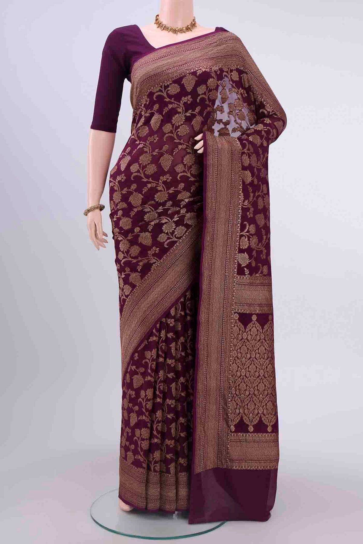 Burgundy Banarasi Georgette Saree with Zari Brocade on the body and Zari Border displayed on a mannequin