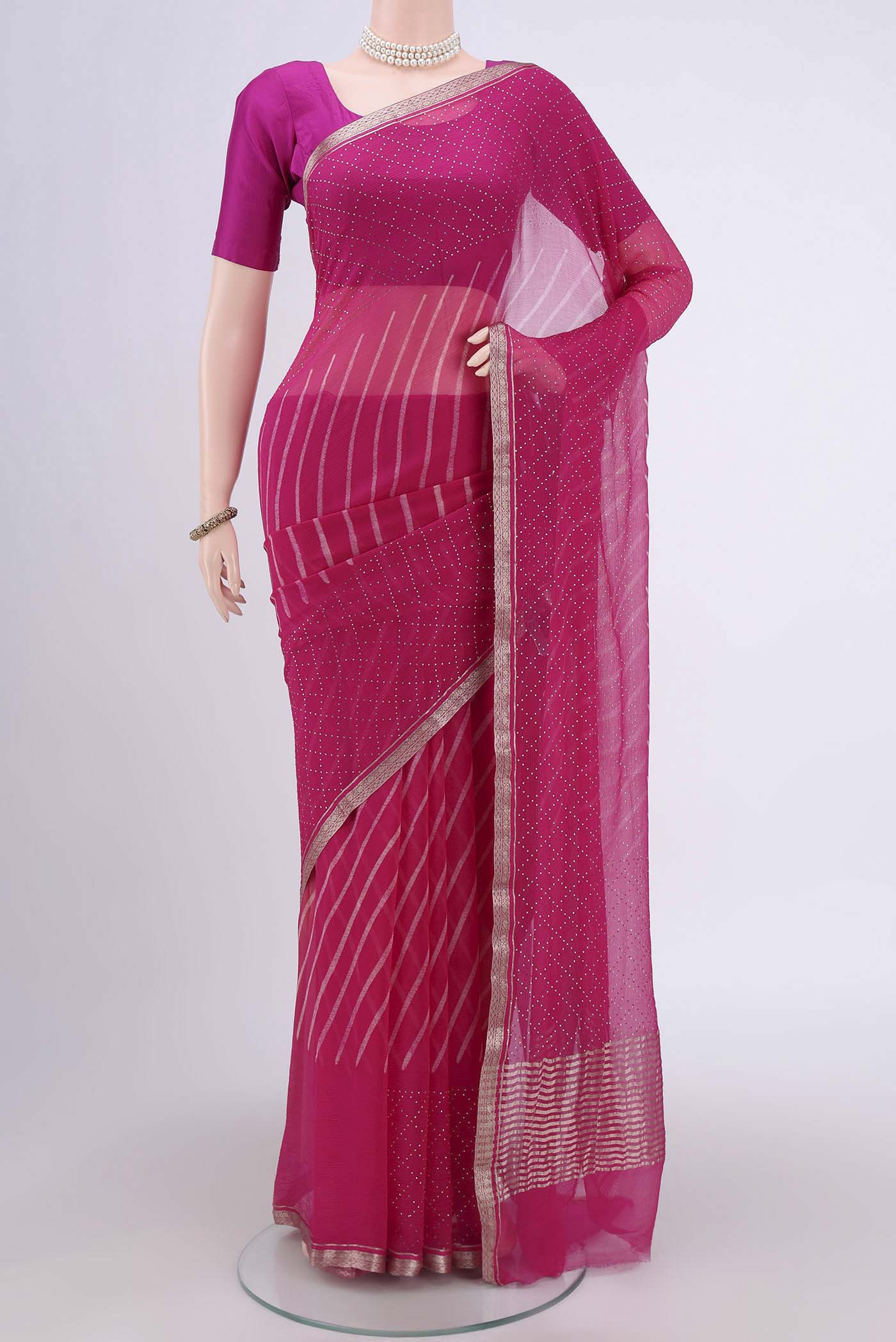 Rani Pink Mysore Chiffon Saree with Printed design on the body and Zari Border.  displayed on a mannequin