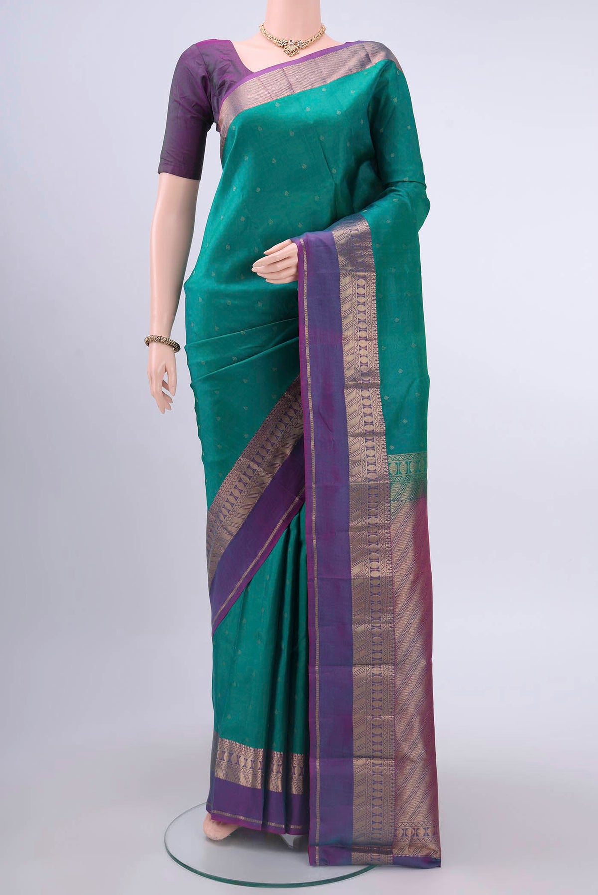 Green Kanchipuram Silk Saree with Zari Butta on the body and Zari Border displayed on a mannequin