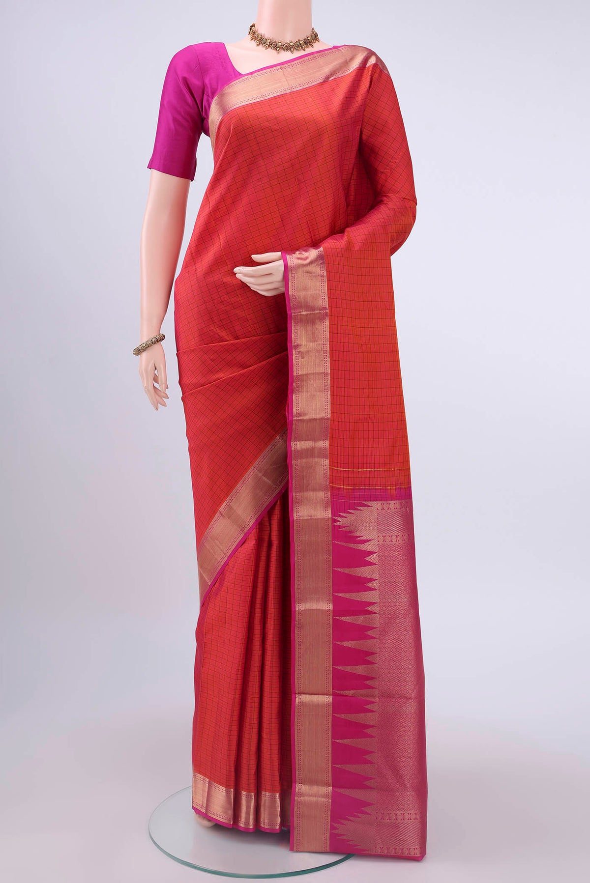 Orange Kanchipuram Silk Saree with Checked design on the body and Zari Border displayed on a mannequin