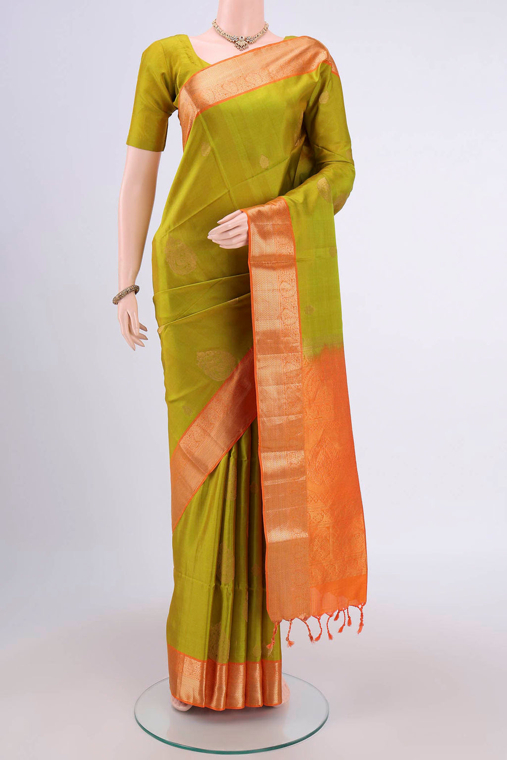 Light Green Soft Silk Saree with Zari Butta on the body and Zari Border.  displayed on a mannequin