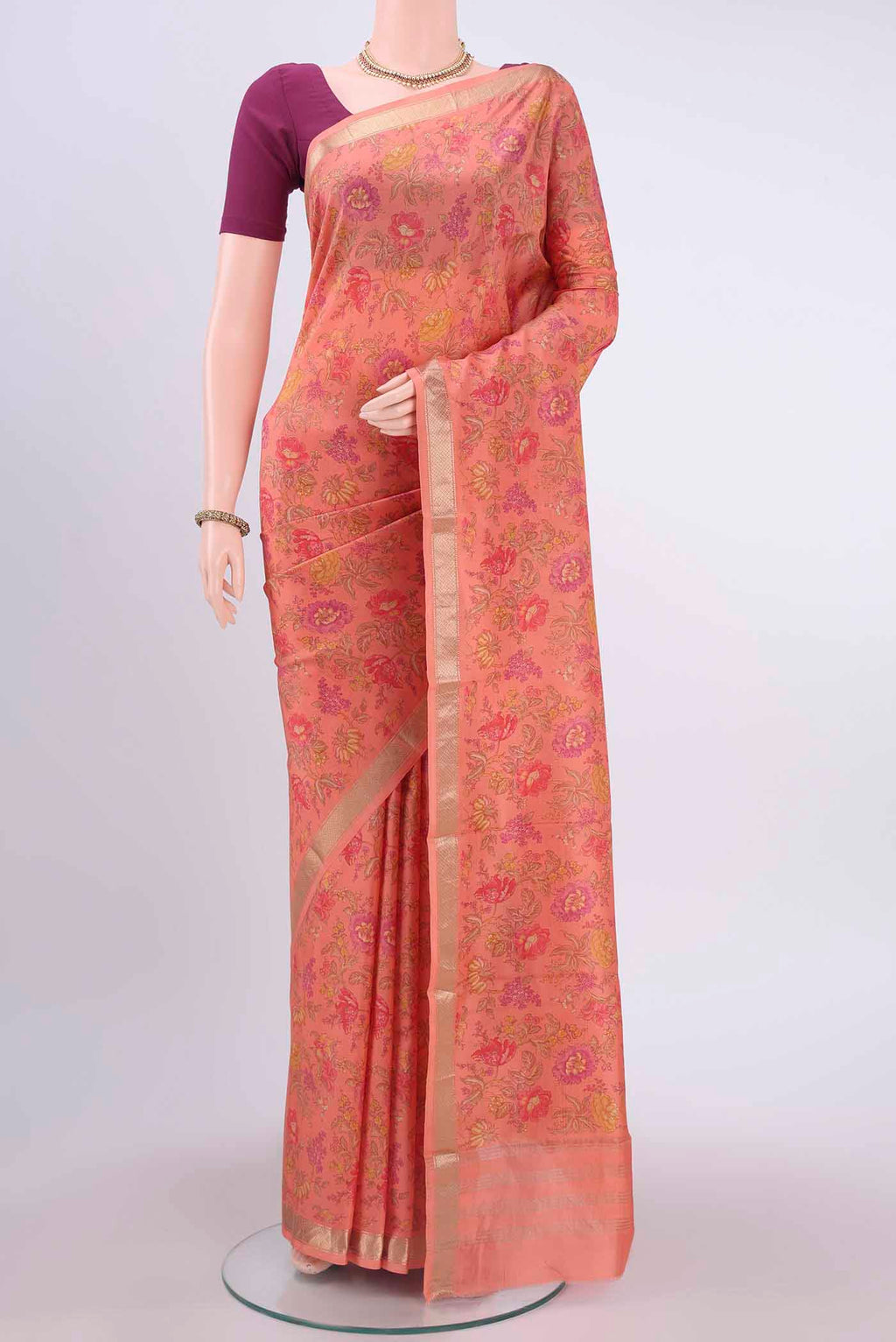 Peach Printed Silk Saree with Floral Print on the body and Zari Border displayed on a mannequin