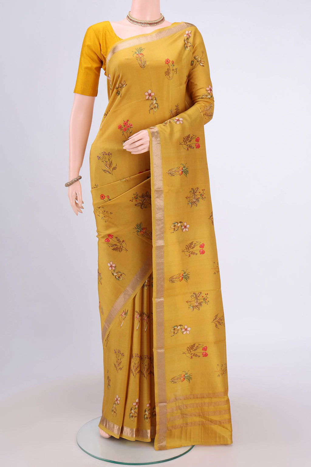 Mustard Mysore Crepe Saree with Floral Print on the body and Zari Border.  displayed on a mannequin