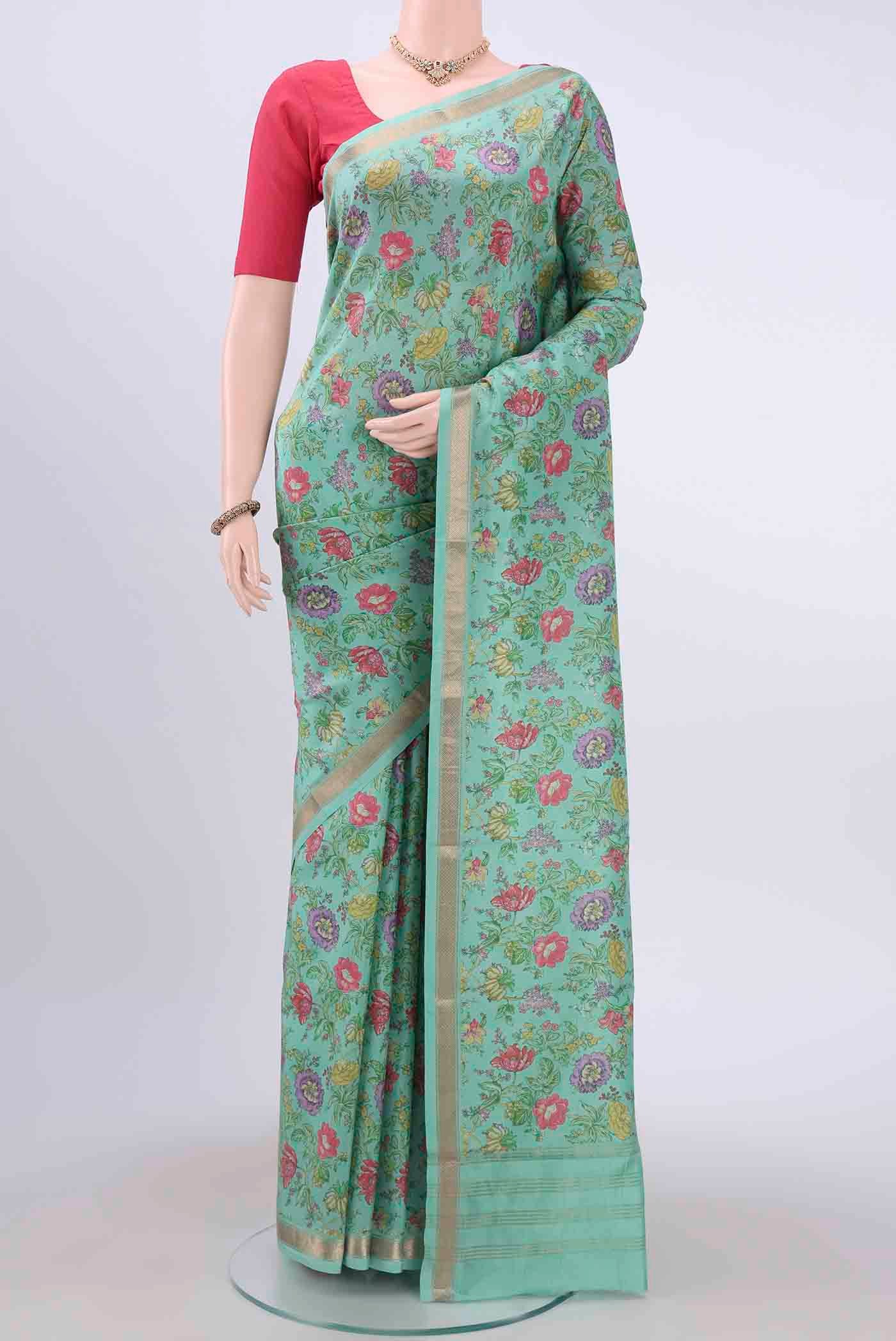 Mint Green Printed Silk Saree with Floral Print on the body and Zari Border displayed on a mannequin