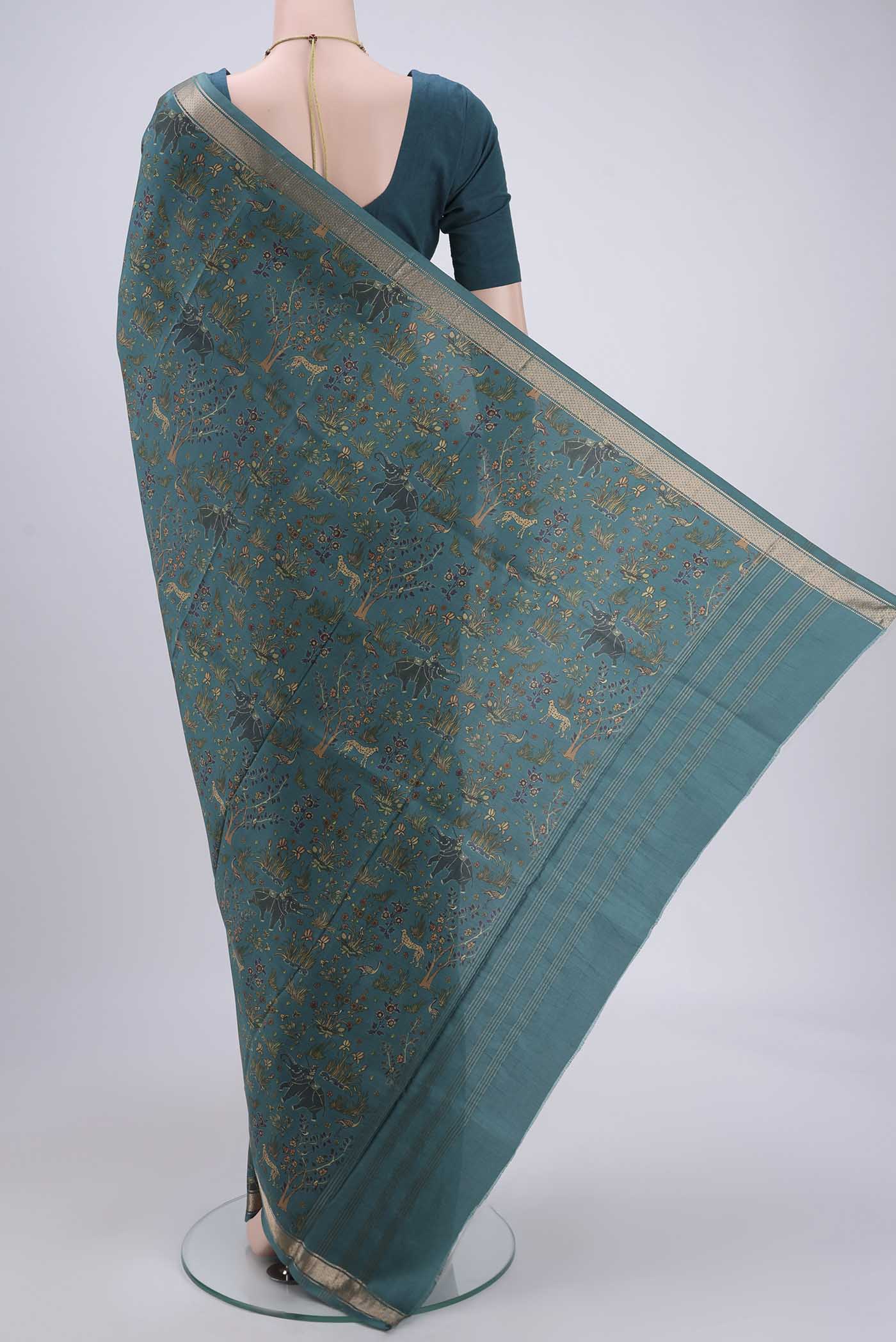 Flat view of Sea Green Printed Silk Saree with Printed design on the body and Zari Border. 