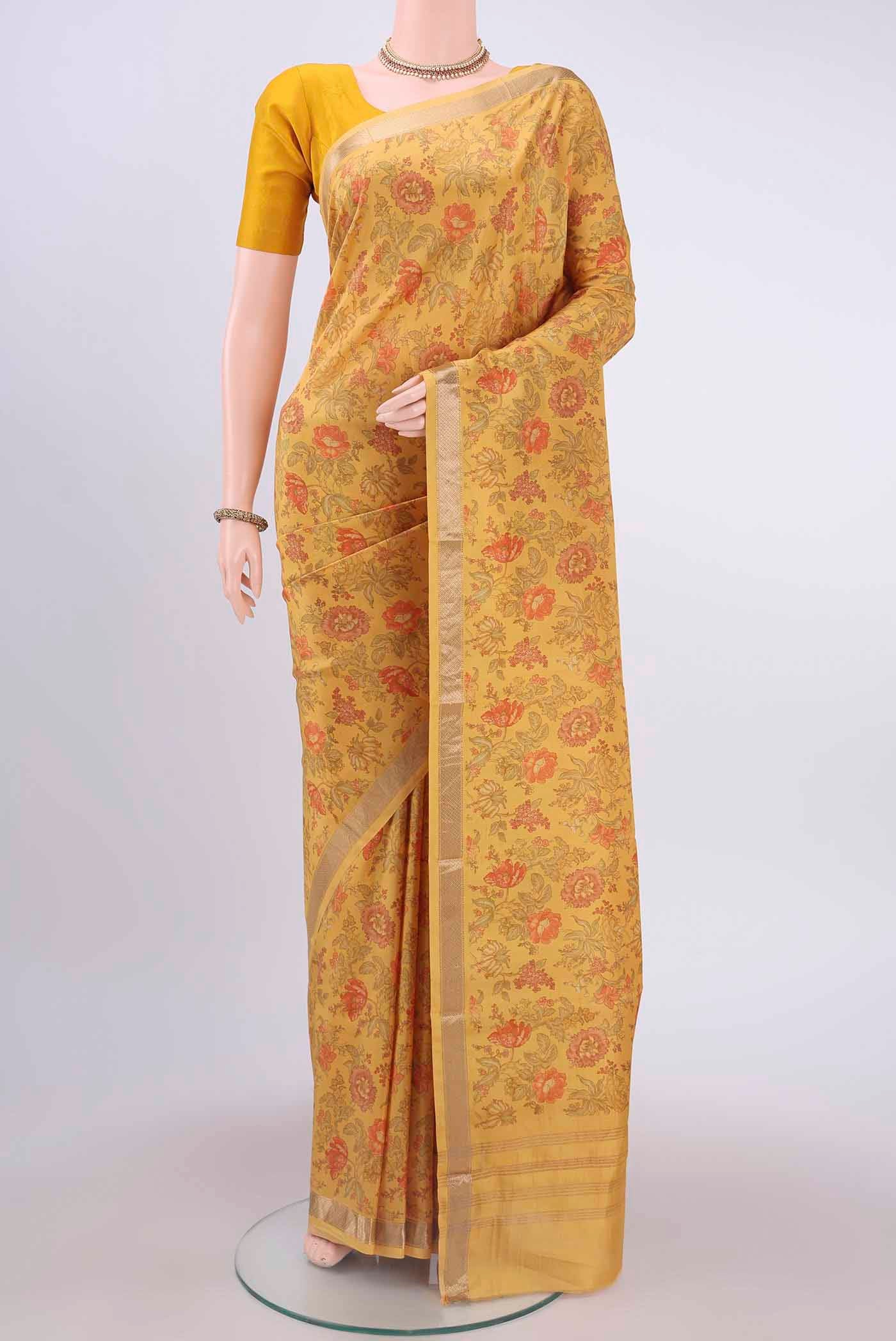Mustard Printed Silk Saree with Floral Print on the body and Zari Border displayed on a mannequin