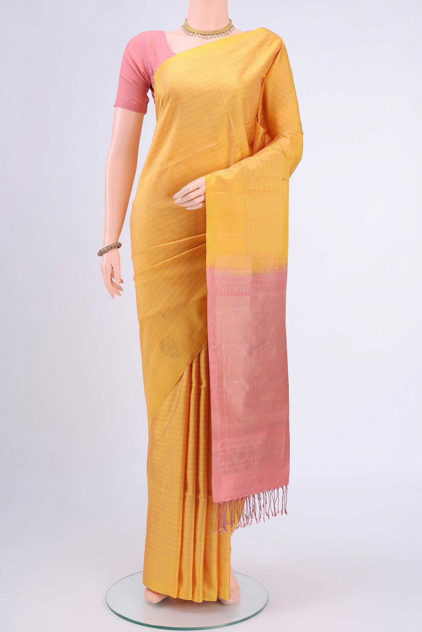 Yellow Soft Silk Saree with Zari Butta on the body and Zari Border displayed on a mannequin