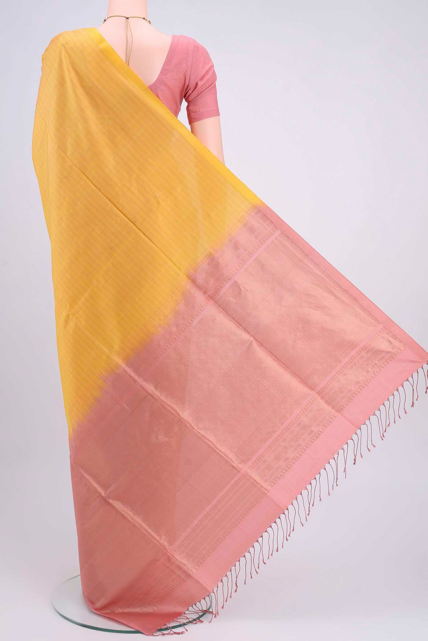 Flat view of Yellow Soft Silk Saree with Zari Butta on the body and Zari Border