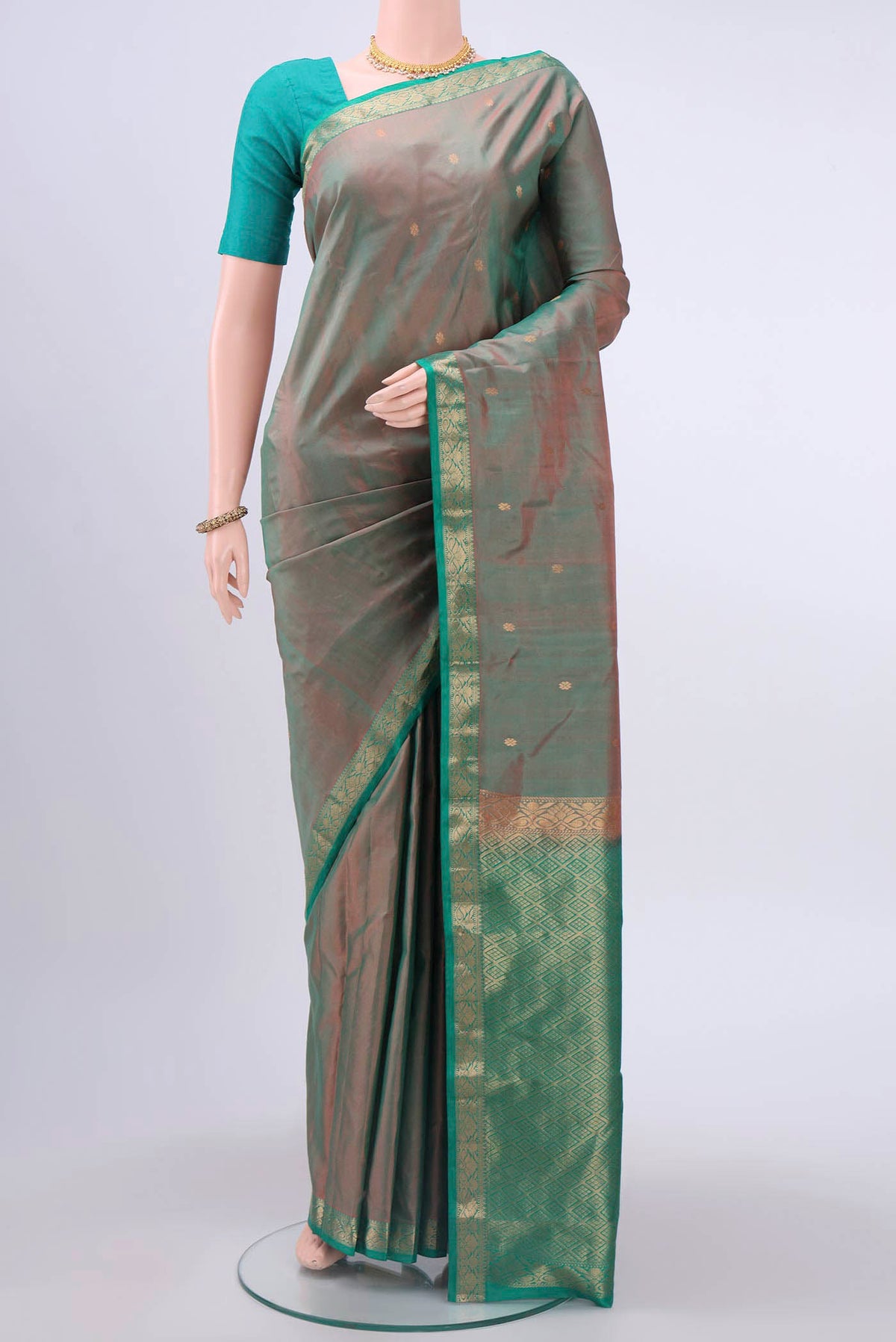 Green with Coral Color Kanchipuram Silk Saree with Zari Butta on the body and Zari Border displayed on a mannequin