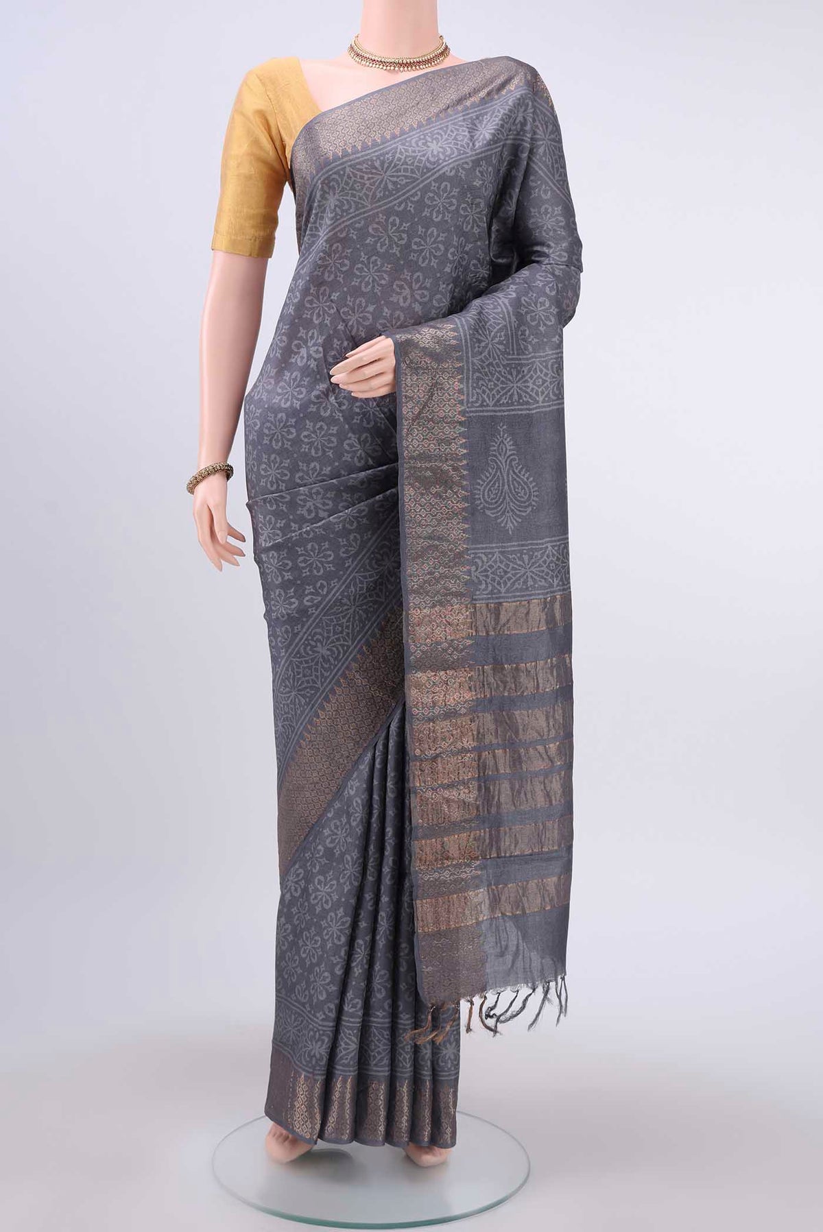 Grey Tussar Silk Saree with Printed design on the body and Zari Border displayed on a mannequin