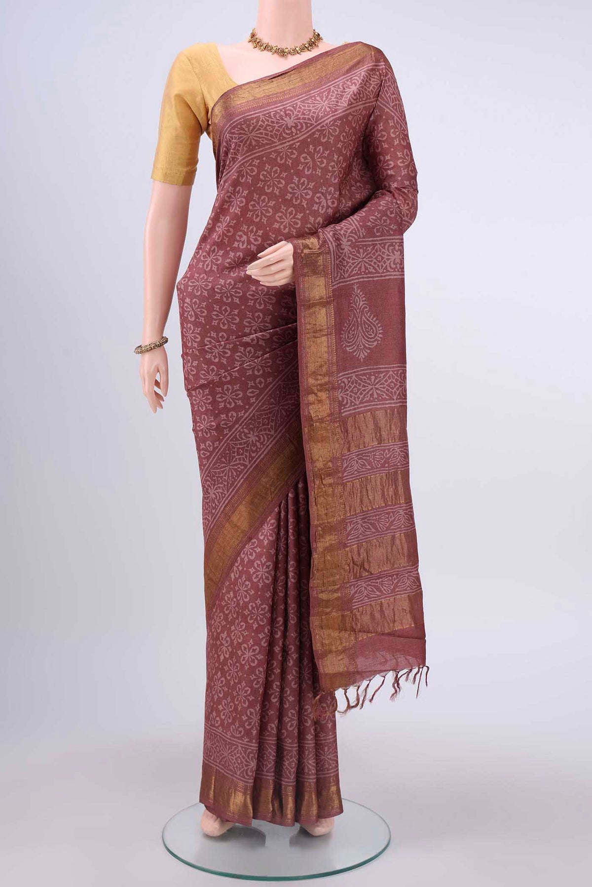Coral Tussar Silk Saree with Printed design on the body and Zari Border displayed on a mannequin