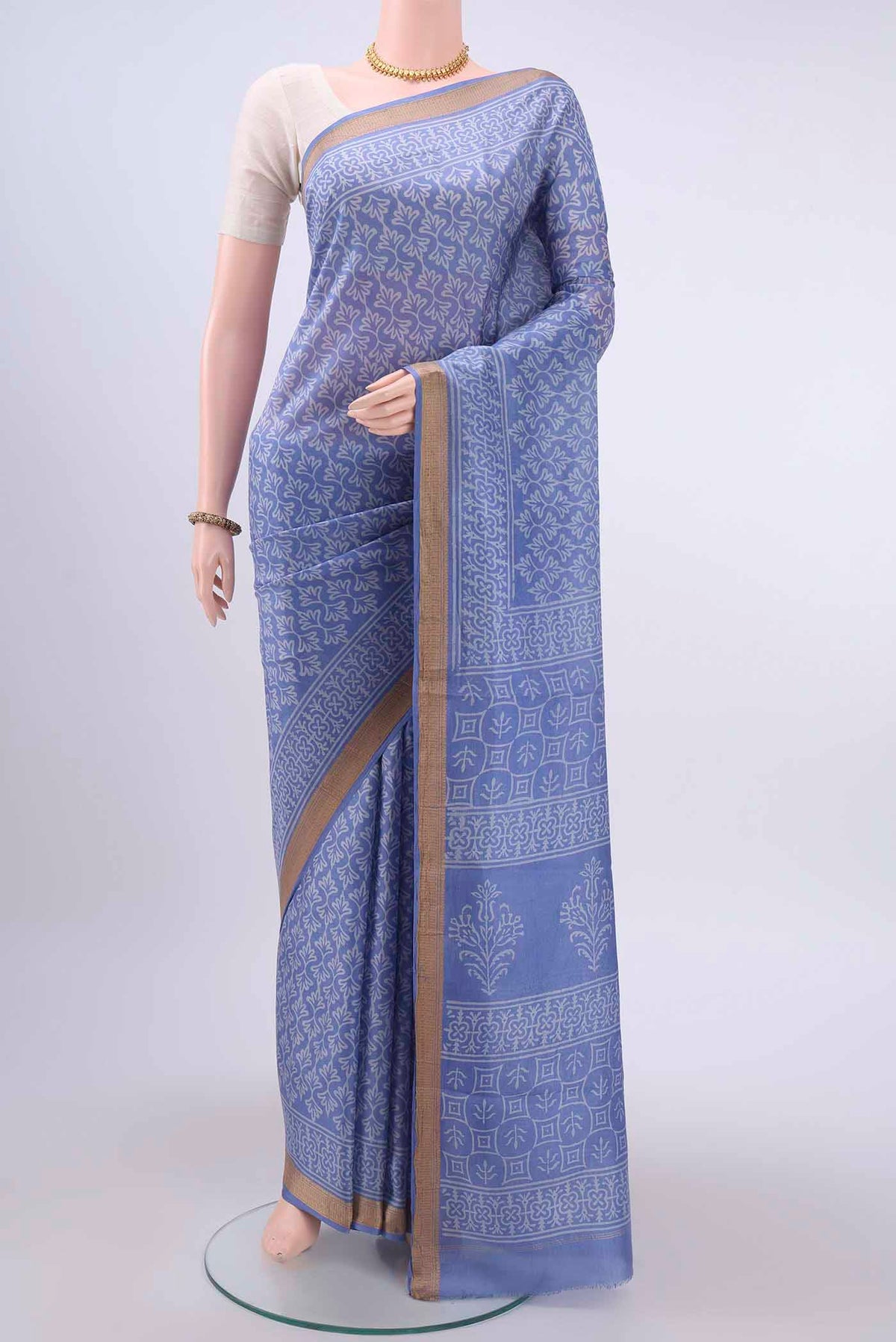 Light Blue Printed Silk Saree with Printed design on the body and Zari Border displayed on a mannequin