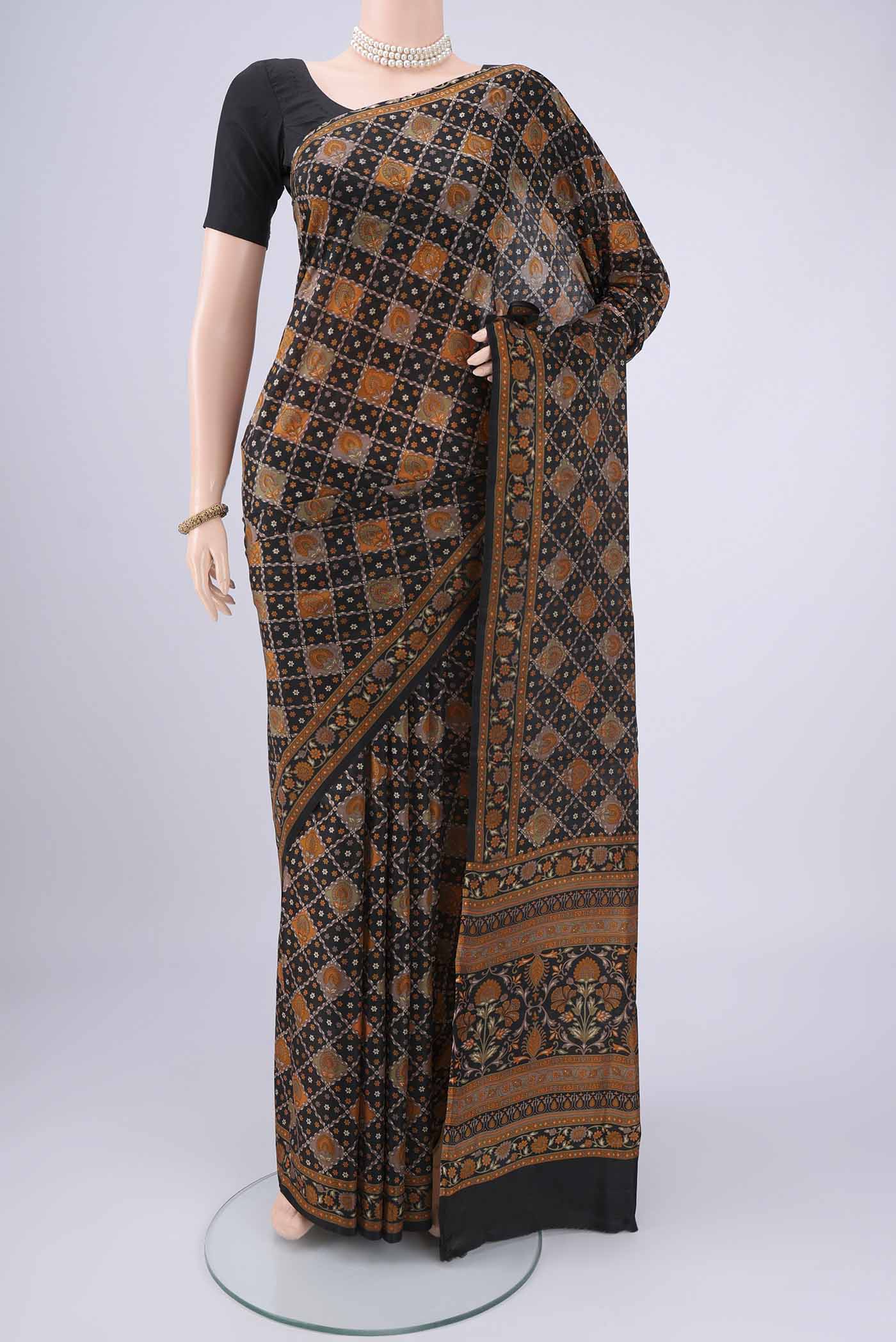 Black Printed Silk Saree with Floral Print on the body and Printed Border.  displayed on a mannequin