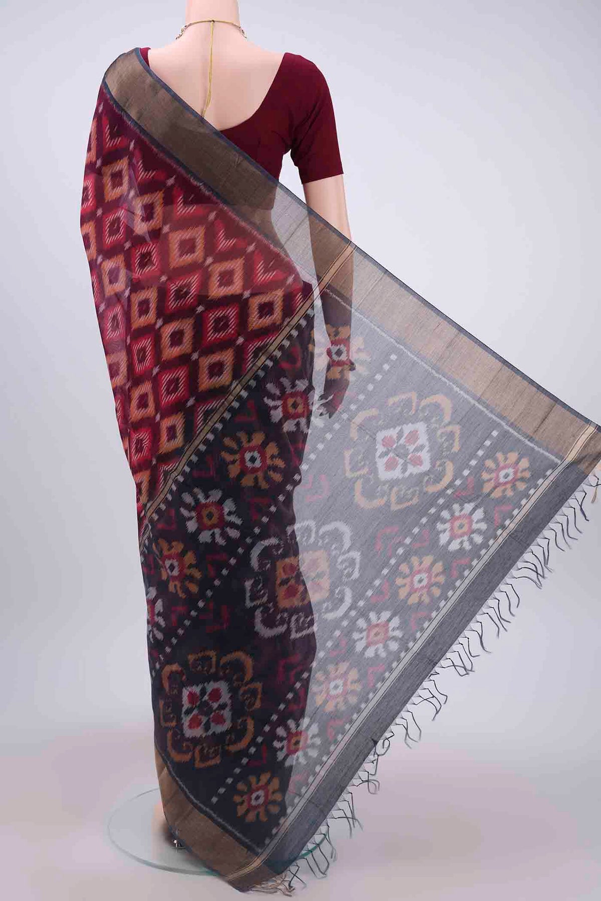 Flat view of Maroon Kora Cotton Saree with Ikat design on the body and Zari Border