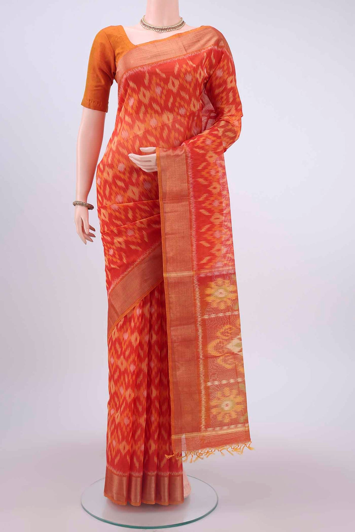 Orange Kora Cotton Saree with Ikat design on the body and Zari Border displayed on a mannequin