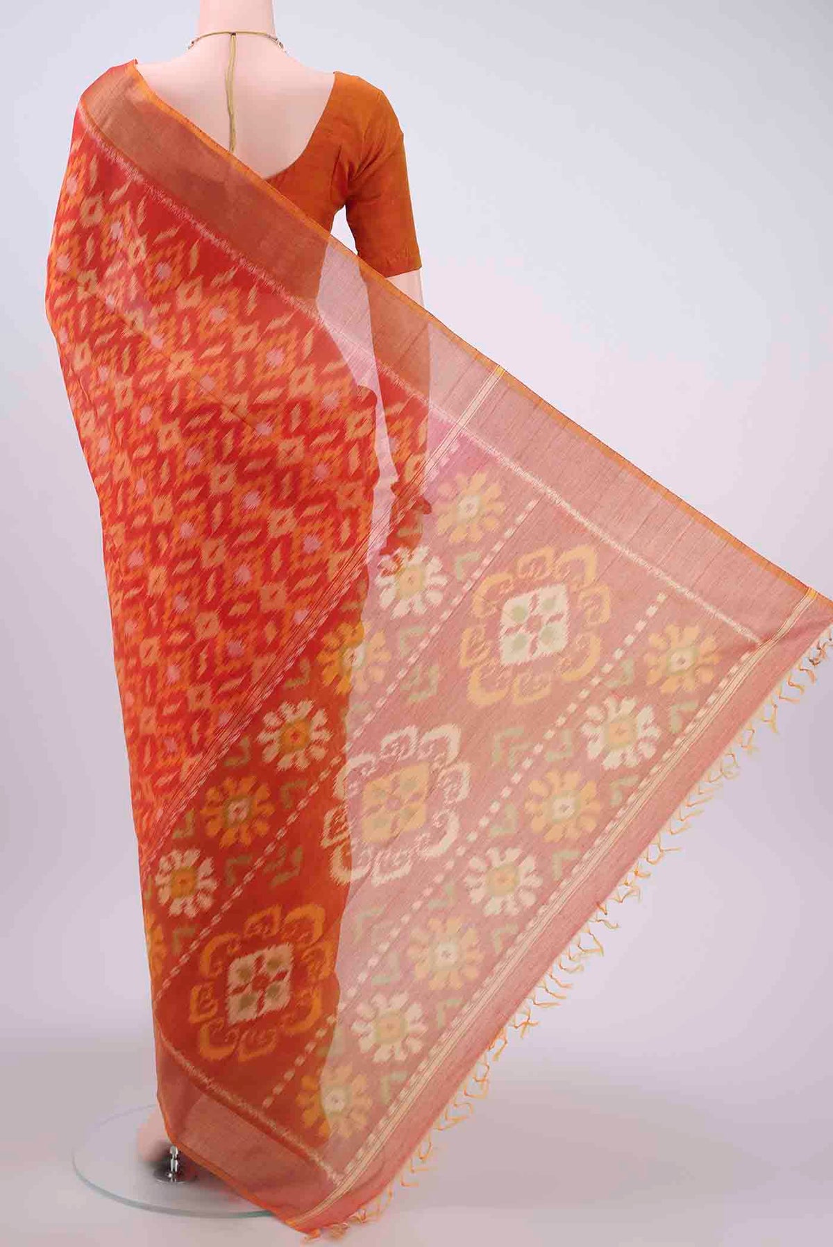 Flat view of Orange Kora Cotton Saree with Ikat design on the body and Zari Border