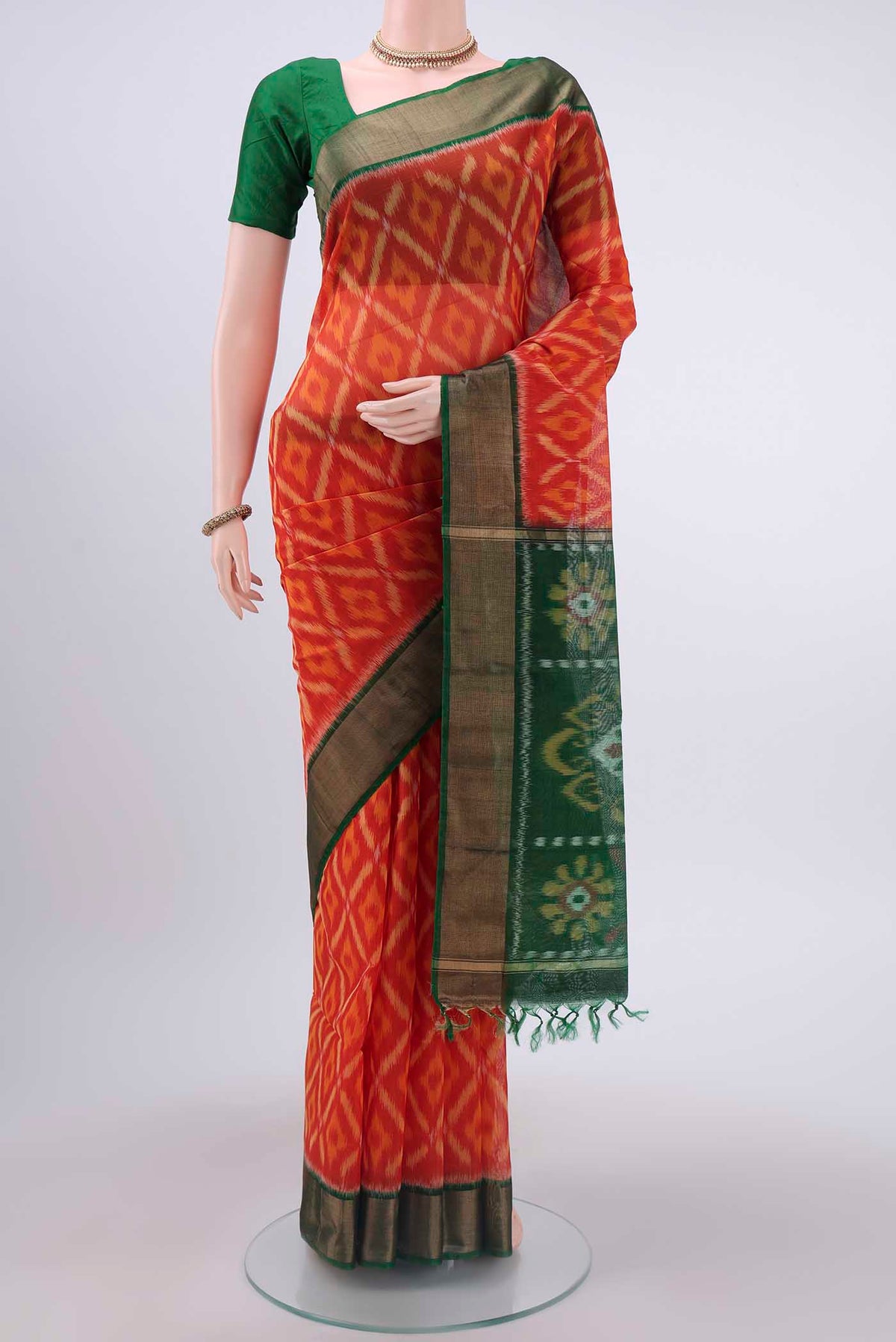 Brick Orange Kora Cotton Saree with Ikat design on the body and Zari Border displayed on a mannequin