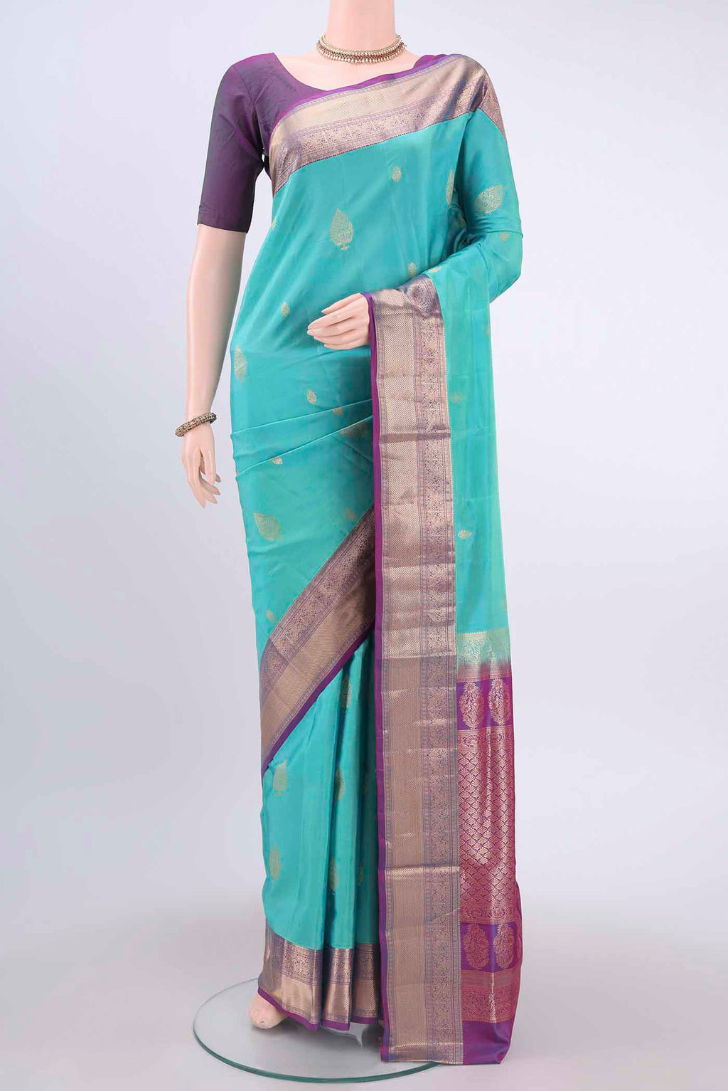 Light Blue Soft Silk Saree with Zari Butta on the body and Zari Border displayed on a mannequin