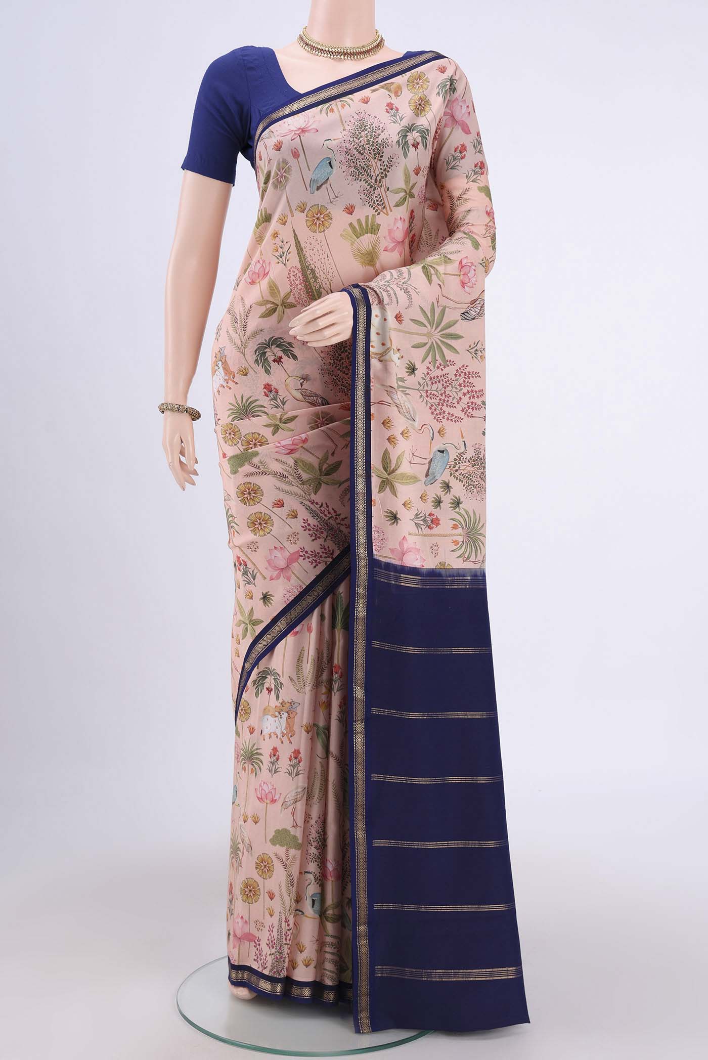 Peach Mysore Crepe Saree with Floral Print on the body and Zari Border.  displayed on a mannequin