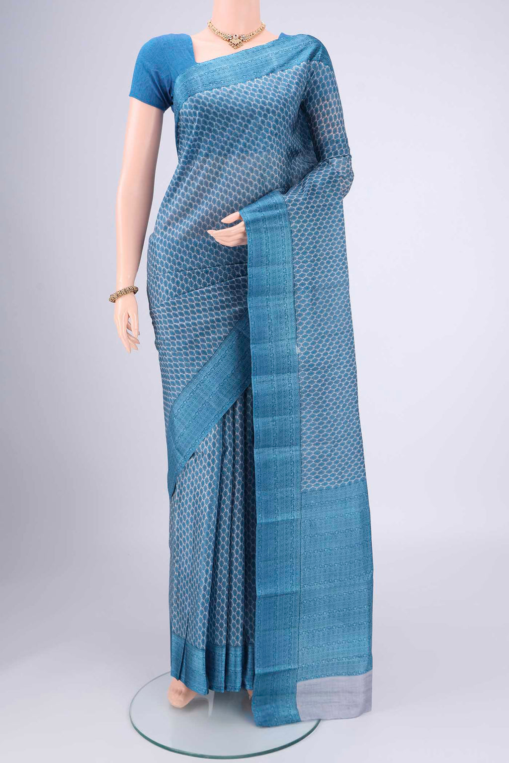 Blue Grey Printed Silk Saree with Floral Print on the body and Printed Border.  displayed on a mannequin
