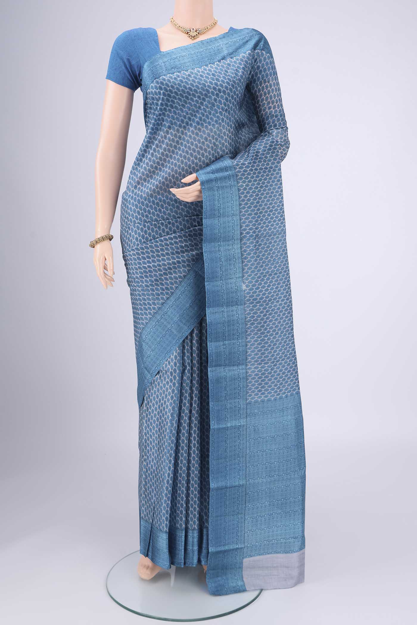 Blue Grey Printed Silk Saree with Floral Print on the body and Printed Border.  displayed on a mannequin