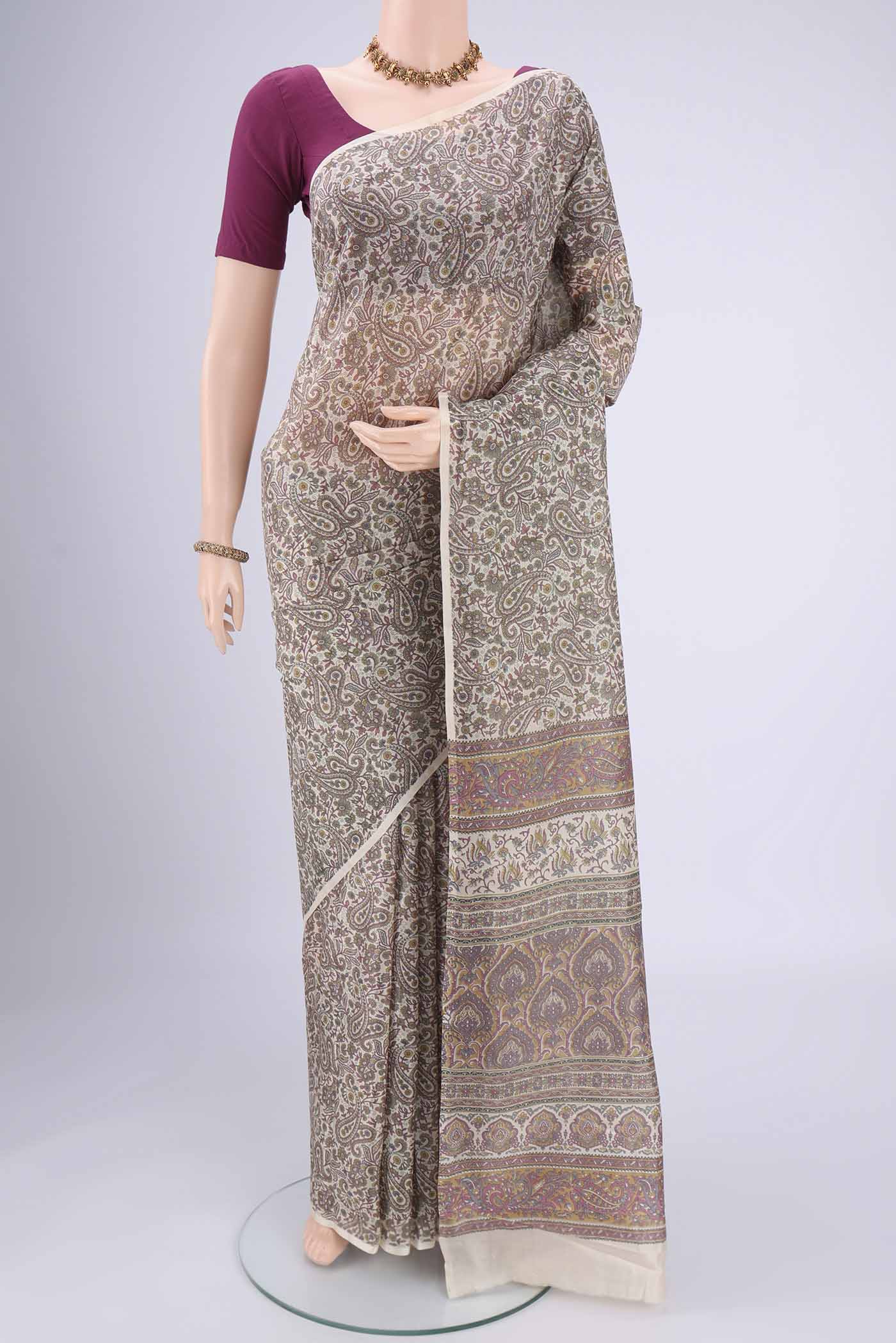 Off White Printed Silk Saree with Floral Print on the body and Printed Border.  displayed on a mannequin