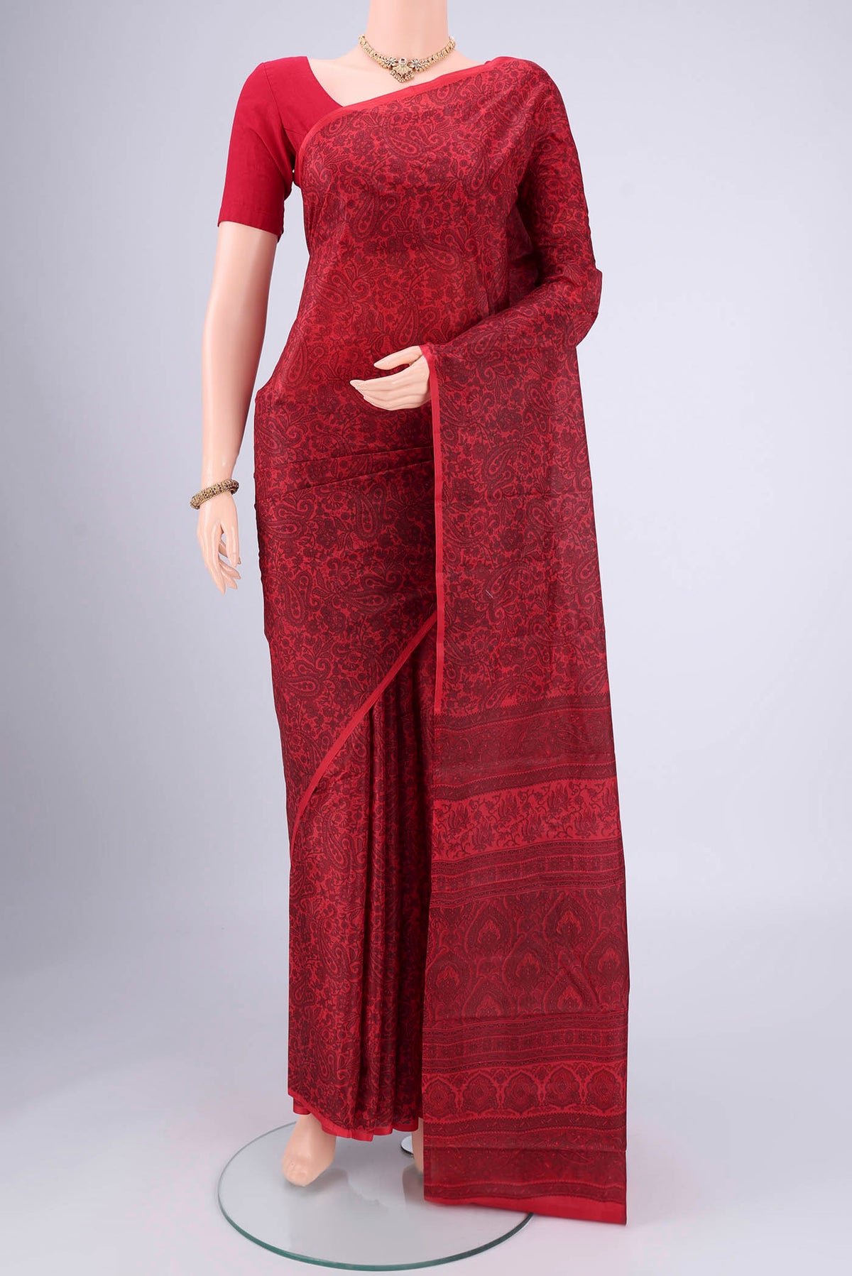 Red Printed Silk Saree with Floral Print on the body and Printed Border.  displayed on a mannequin