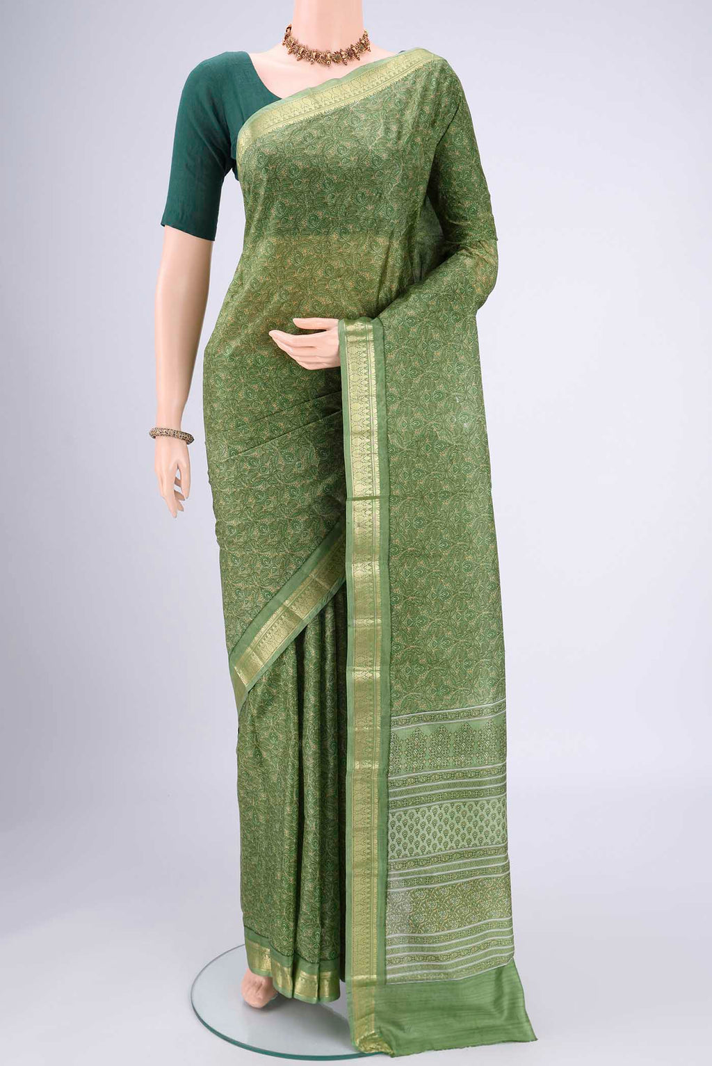 Light Green Printed Silk Saree with Printed design on the body and Zari Border.  displayed on a mannequin