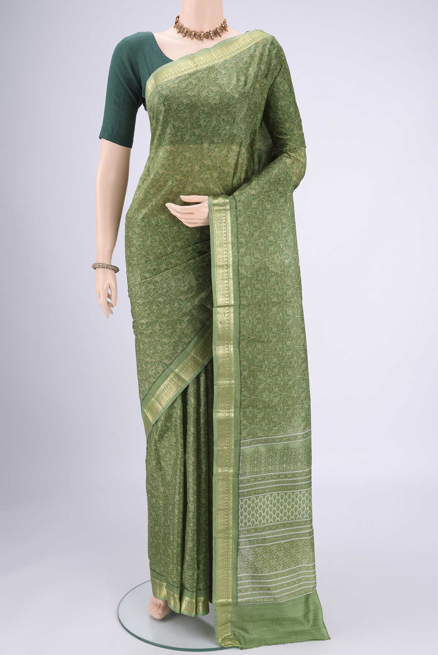 Light Green Printed Silk Saree with Printed design on the body and Zari Border.  displayed on a mannequin