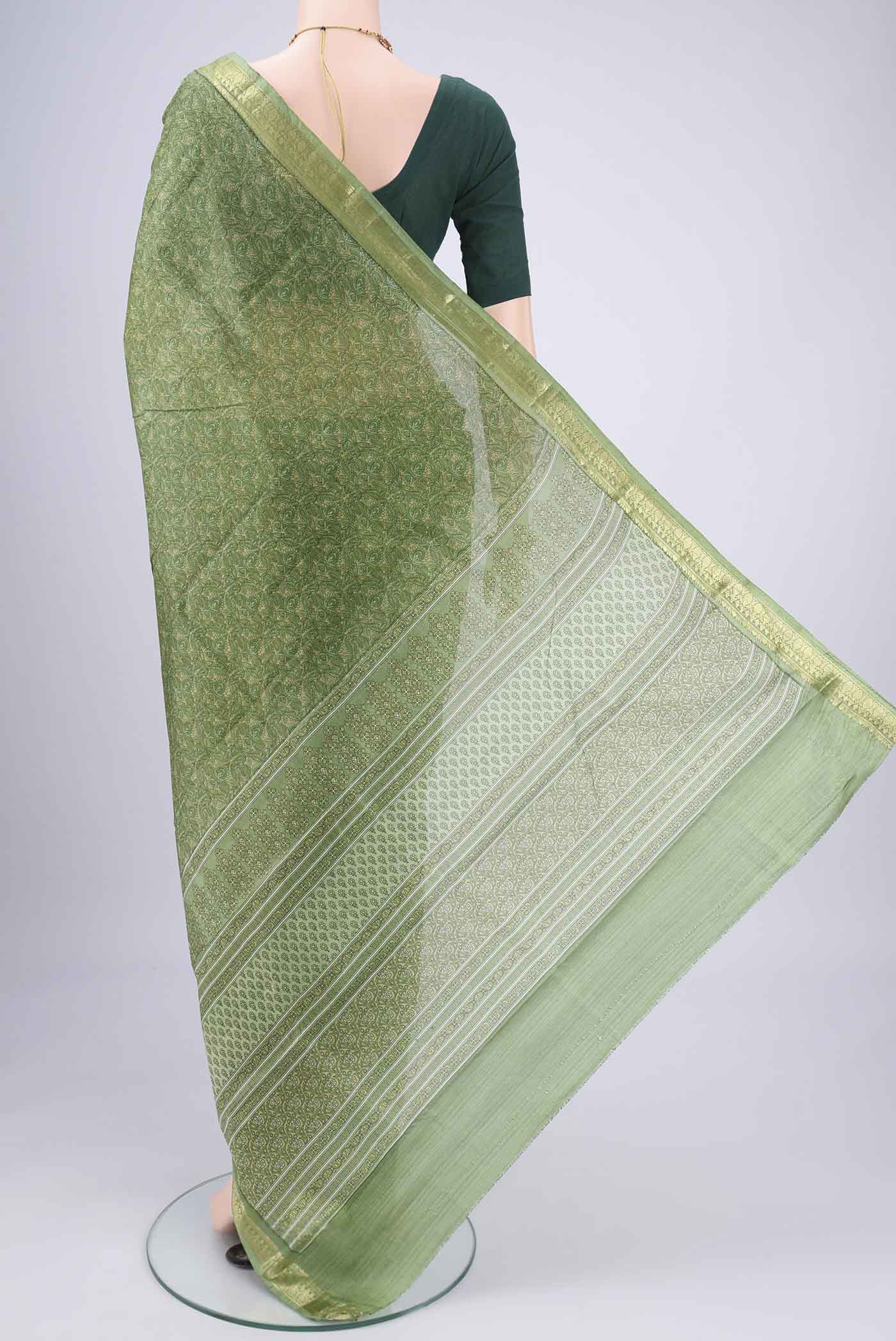 Flat view of Light Green Printed Silk Saree with Printed design on the body and Zari Border. 