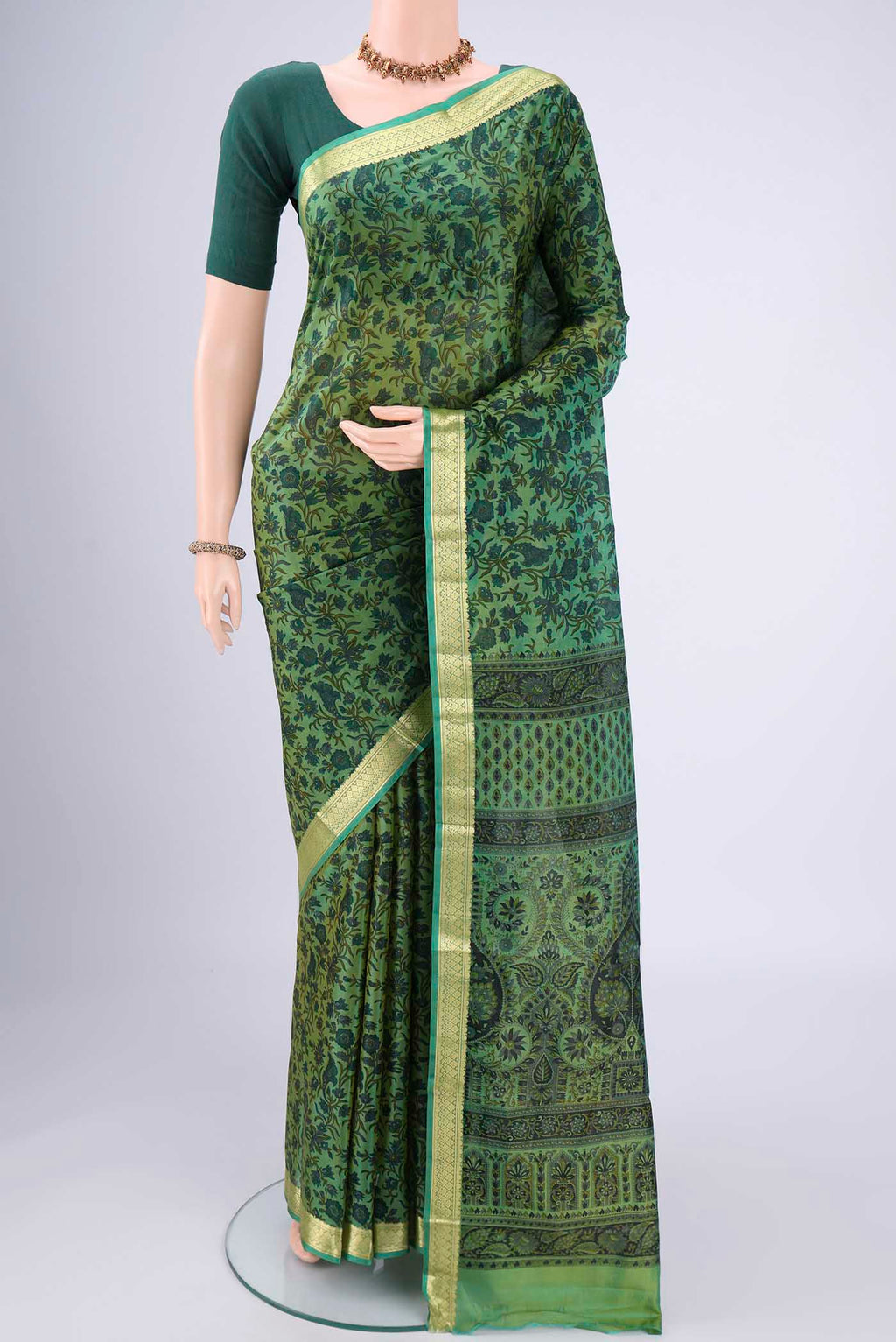 Green Printed Silk Saree with Printed design on the body and Zari Border.  displayed on a mannequin