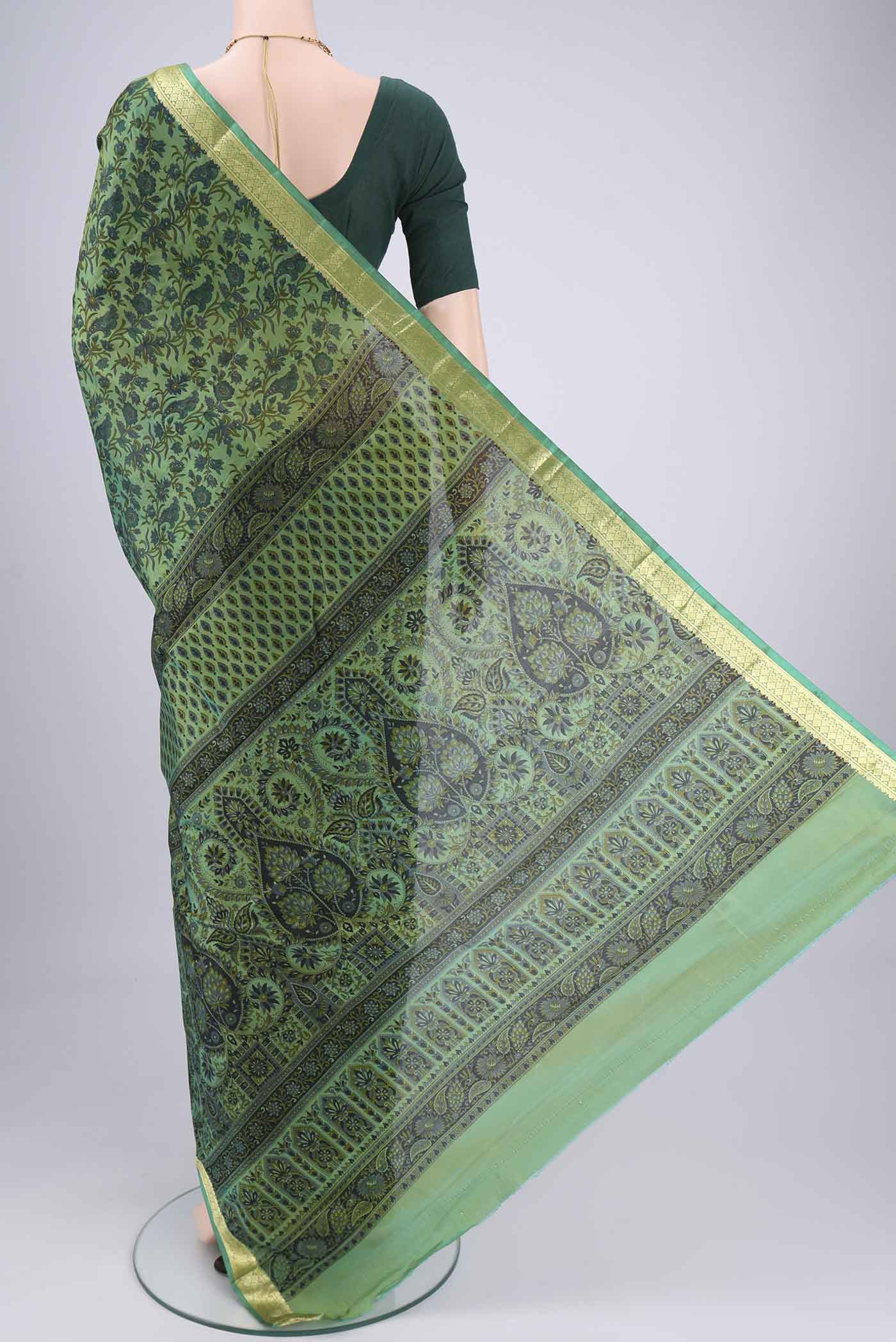 Flat view of Green Printed Silk Saree with Printed design on the body and Zari Border. 