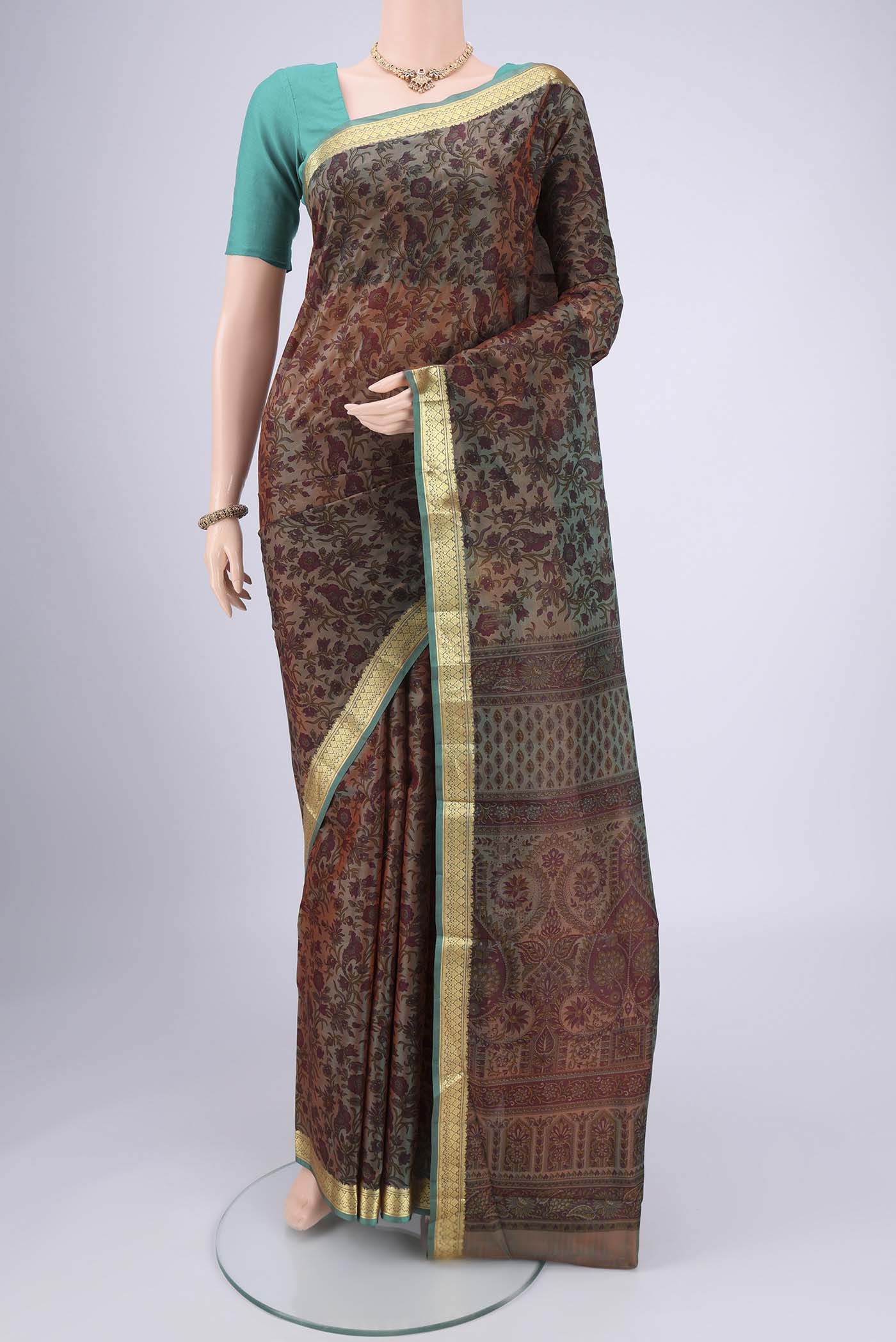 Pickle Green Dual Tone Printed Silk Saree with Printed design on the body and Zari Border.  displayed on a mannequin
