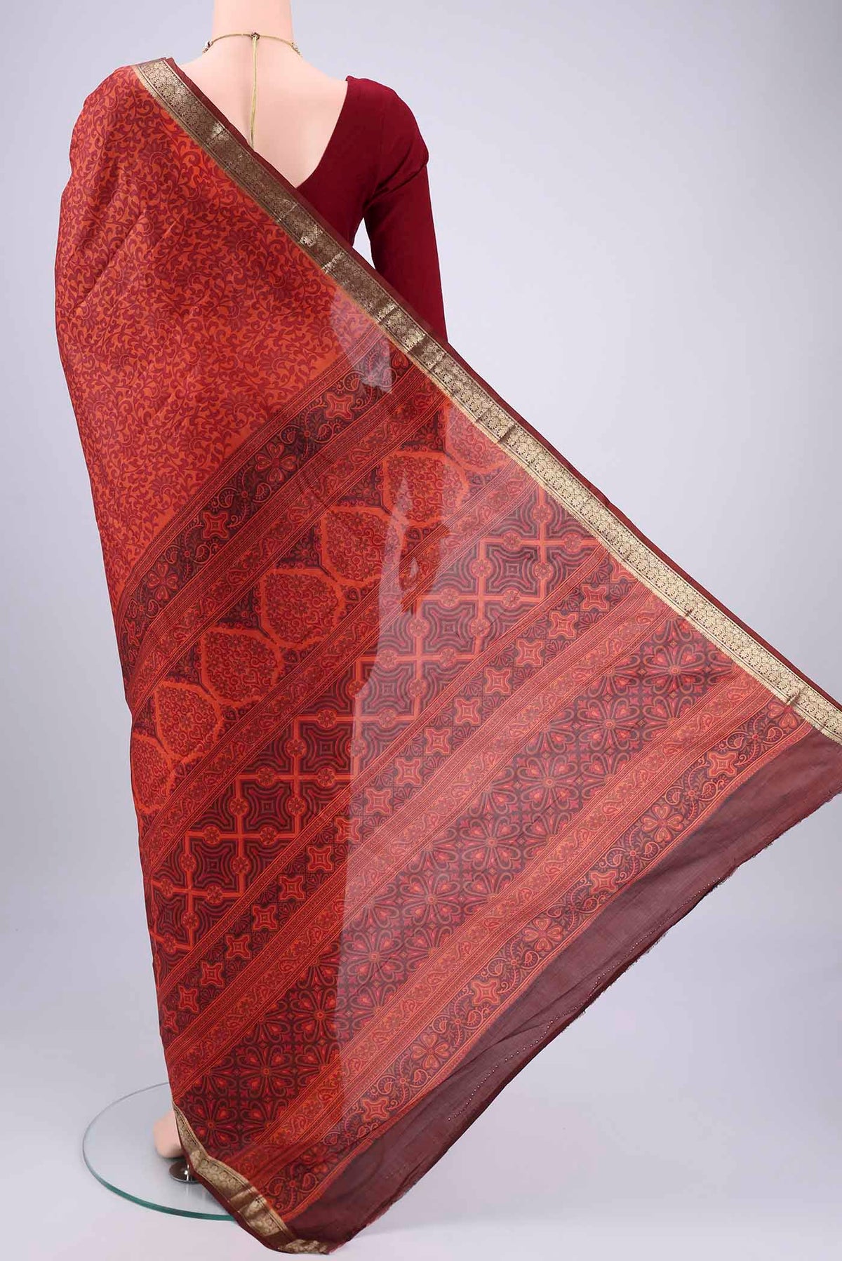 Flat view of Rust Printed Silk Saree with Printed design on the body and Zari Border. 