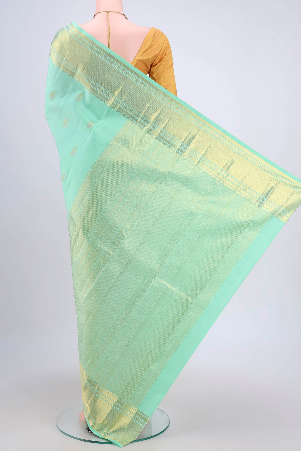 Flat view of Mint Green Kanjivaram Saree with Zari And Thread Butta on the body and Zari Border. 