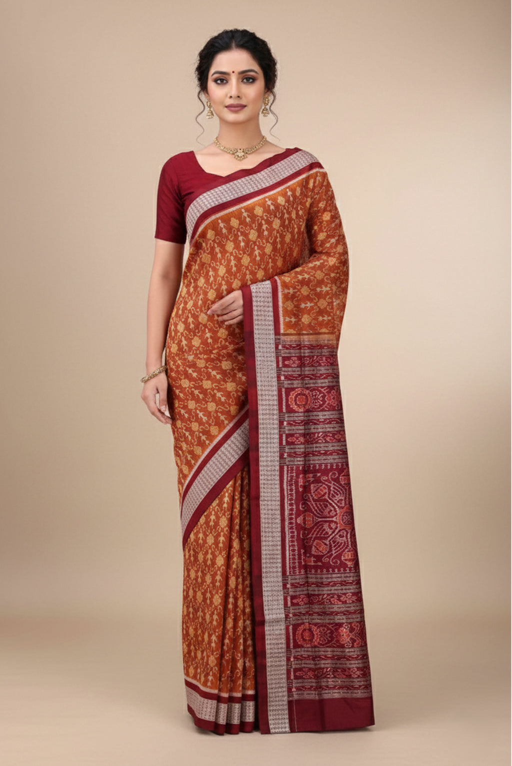 Model wearing a Brown Orissa Silk Saree with Ikat design on the body and Thread Border.