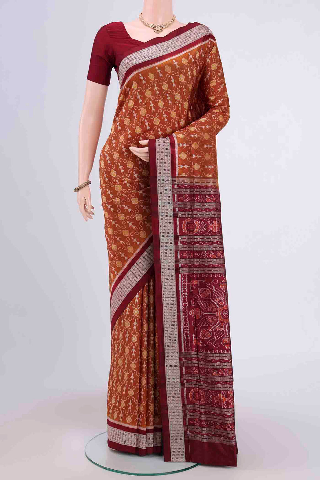 Brown Orissa Silk Saree with Ikat design on the body and Thread Border.  displayed on a mannequin