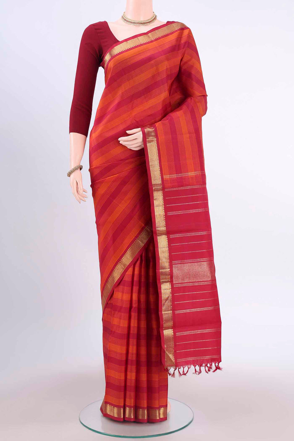 Pure Silk Pure Zari Rust Kanchipuram Saree with Stripes on the body and Plain Border displayed on a mannequin