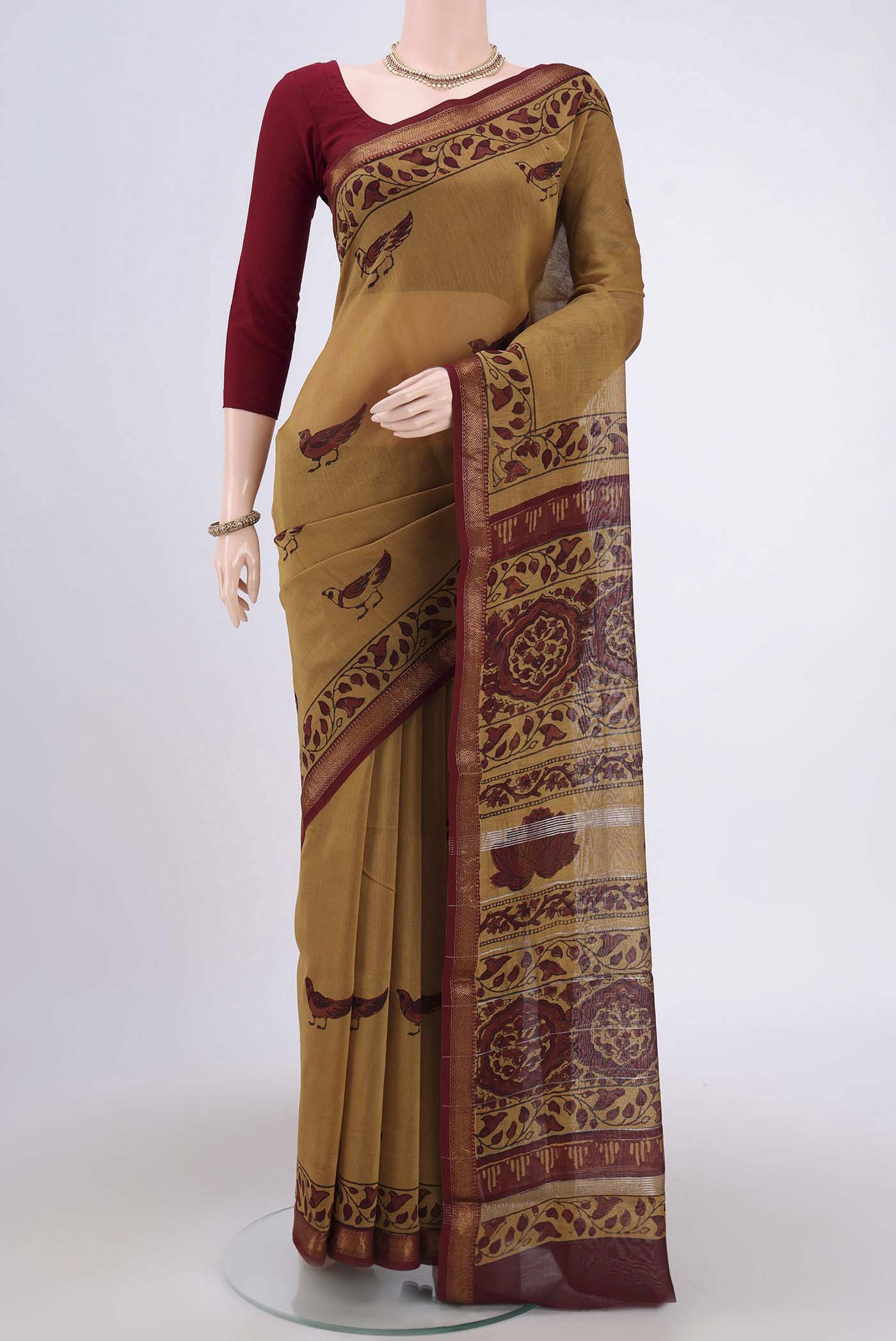 Mustard Maheshwari Silk Cotton Saree with Printed design on the body and Zari Border.  displayed on a mannequin
