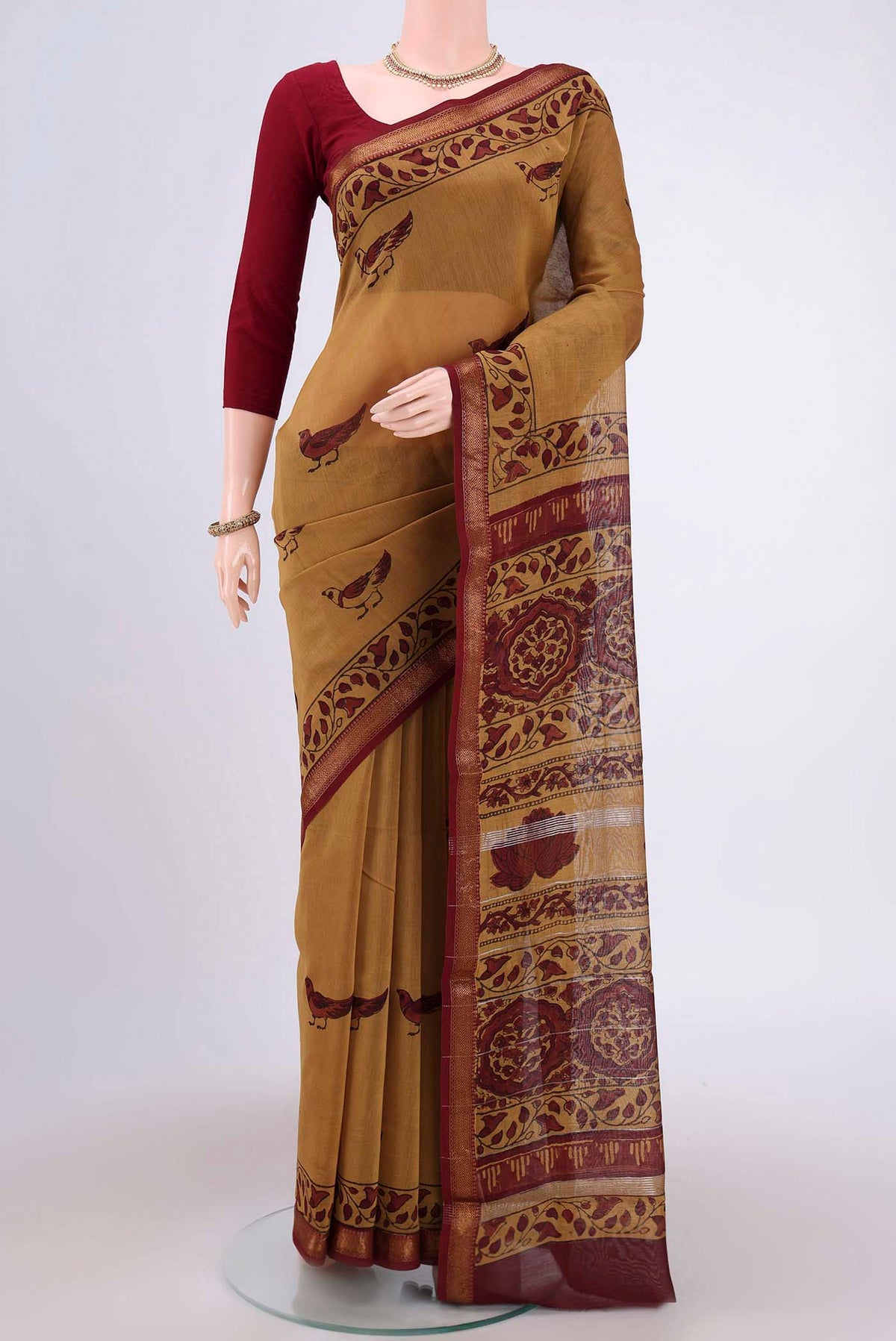 Mustard Maheshwari Silk Cotton Saree with Printed design on the body and Zari Border.  displayed on a mannequin