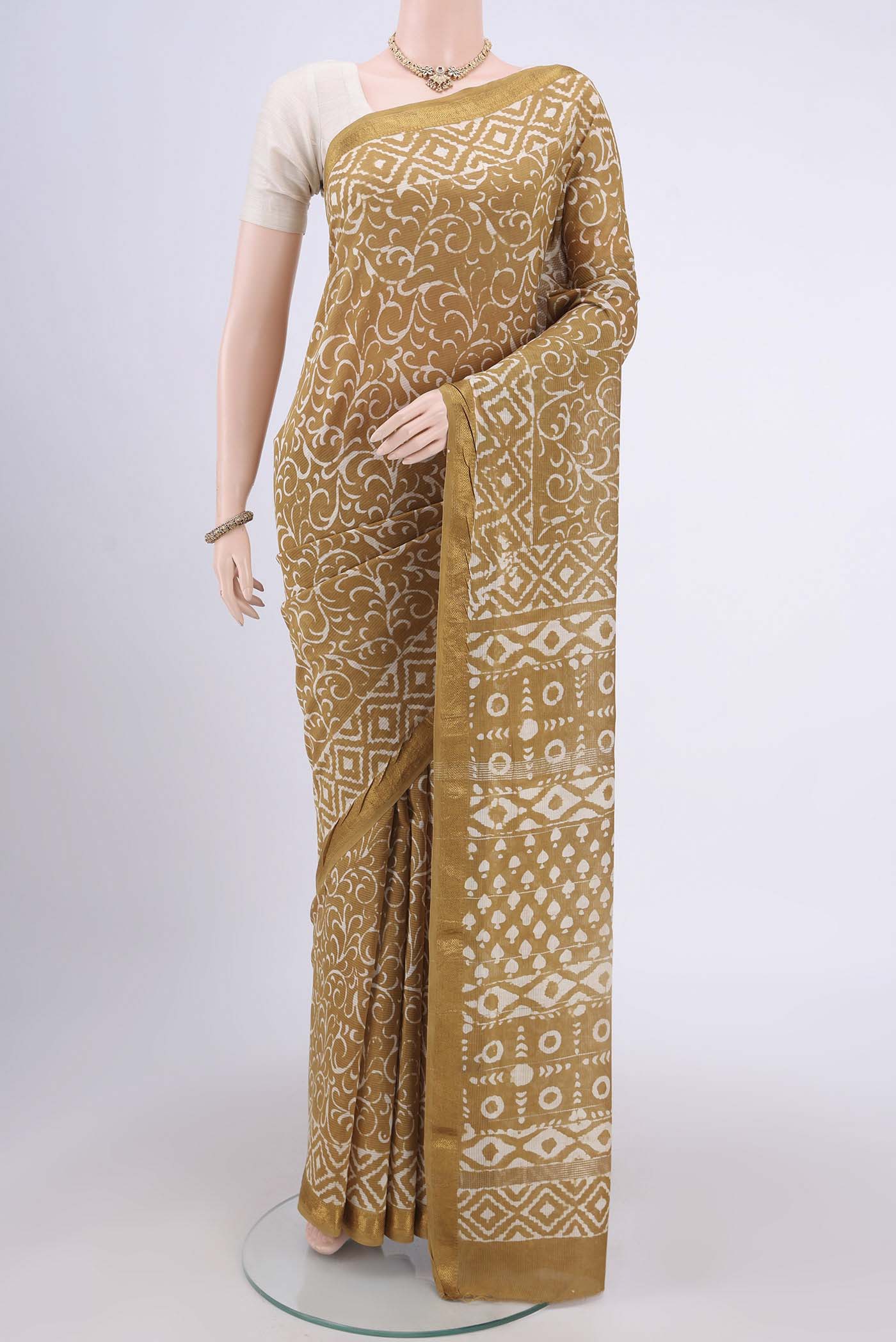Mustard Maheshwari Silk Cotton Saree with Printed design on the body and Zari Border.  displayed on a mannequin