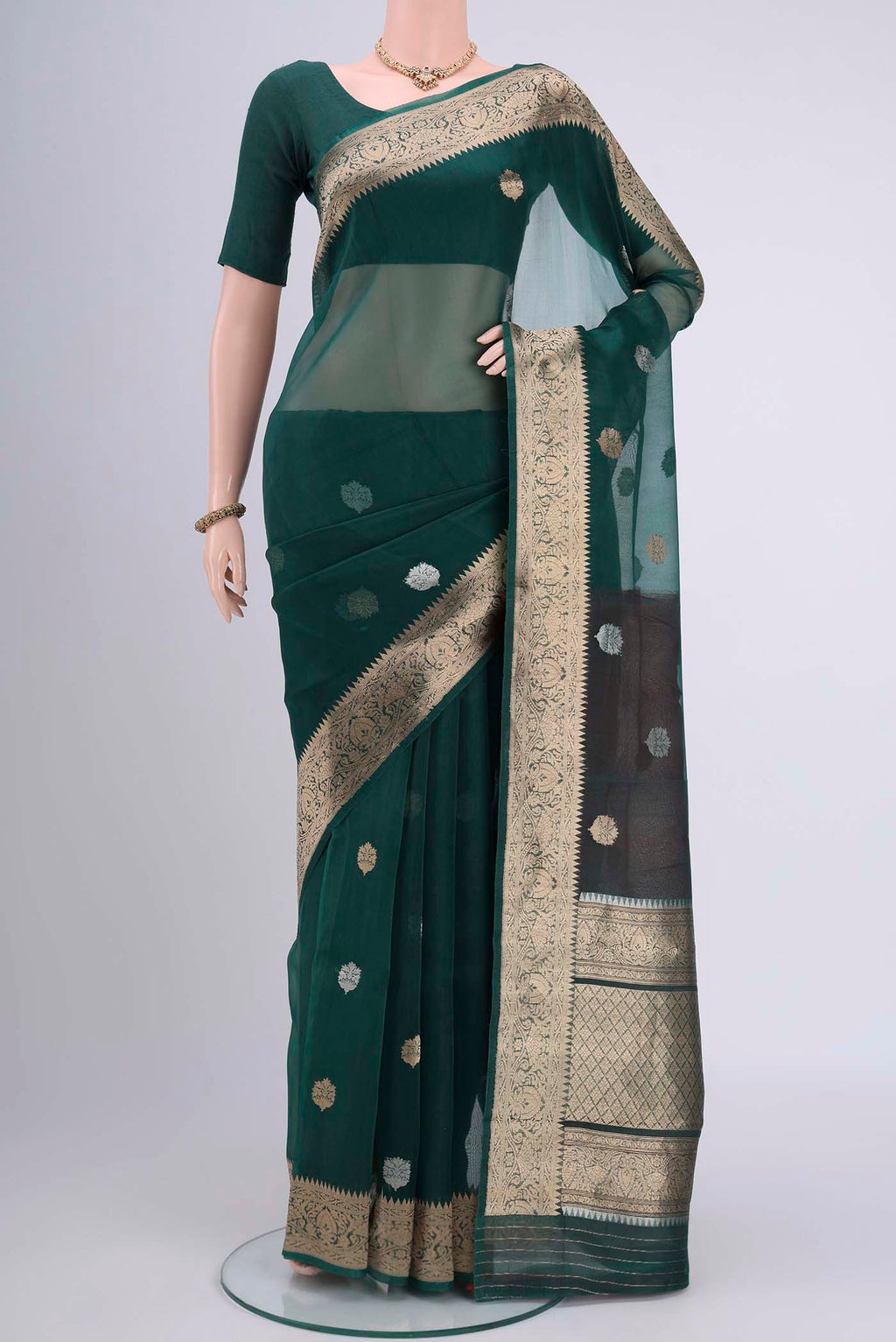 Bottle Green Organza Silk Saree with Plain Body and Zari Border.  displayed on a mannequin